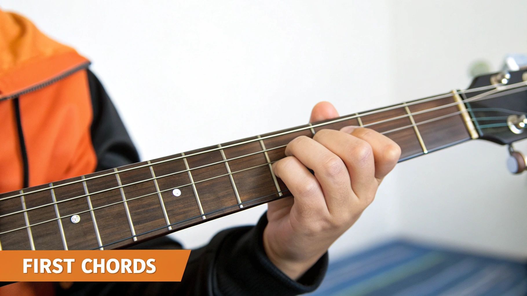 Close-up of a person's hand pressing a chord on a guitar fretboard, with text 'FIRST CHORDS'.