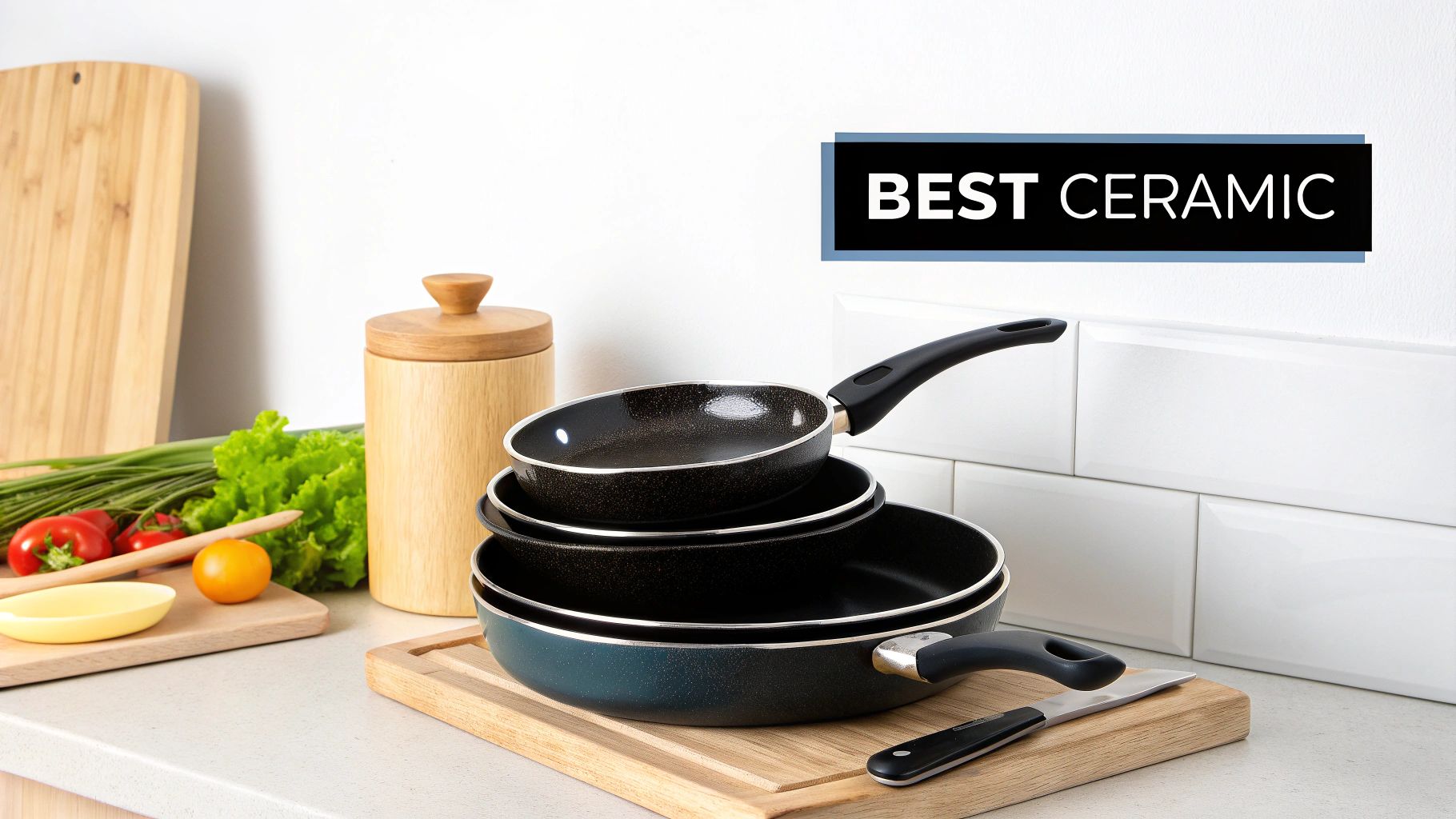 Stack of black ceramic non-stick frying pans and cookware displayed on wooden cutting board in modern kitchen