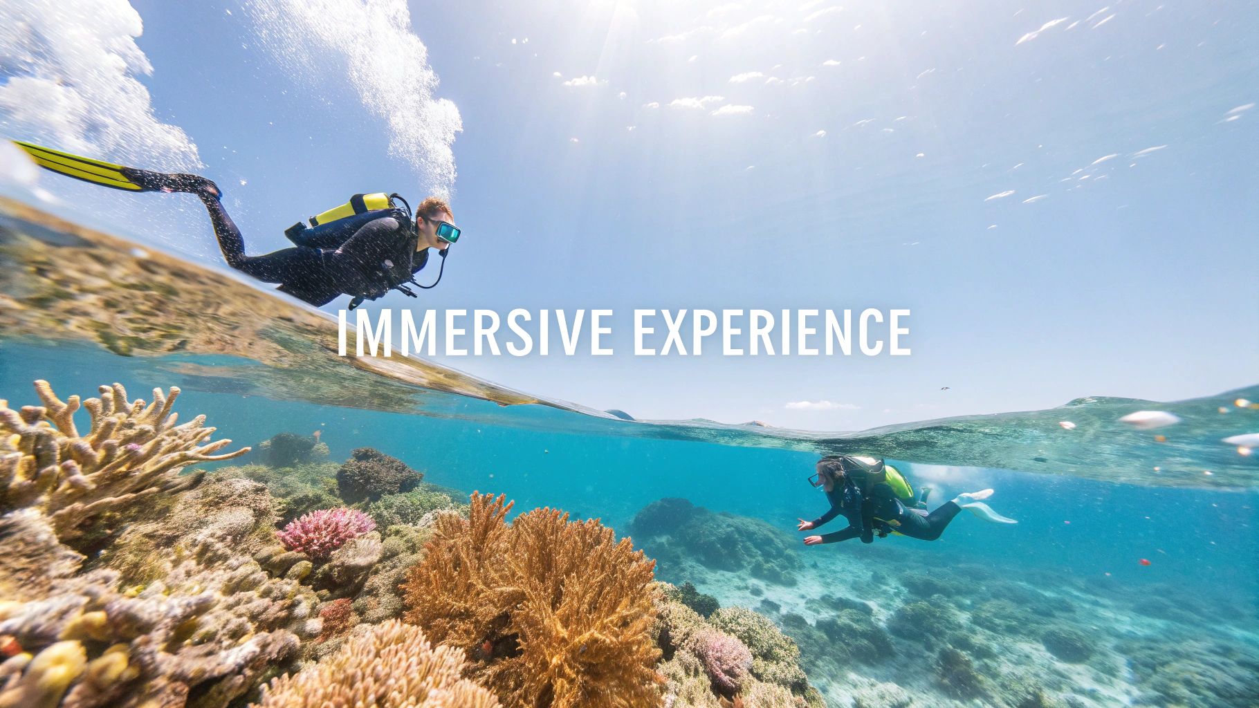 Two divers, one above and one below the water surface, explore a vibrant coral reef.