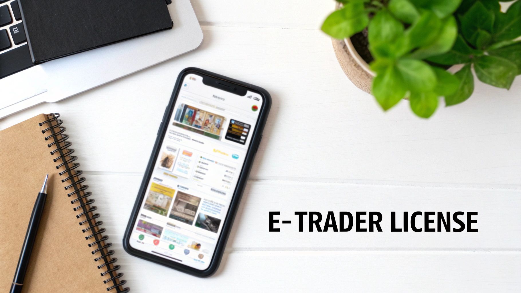 Flat lay of a white desk with a smartphone showing an e-commerce app and 'E-TRADER LICENSE' text.