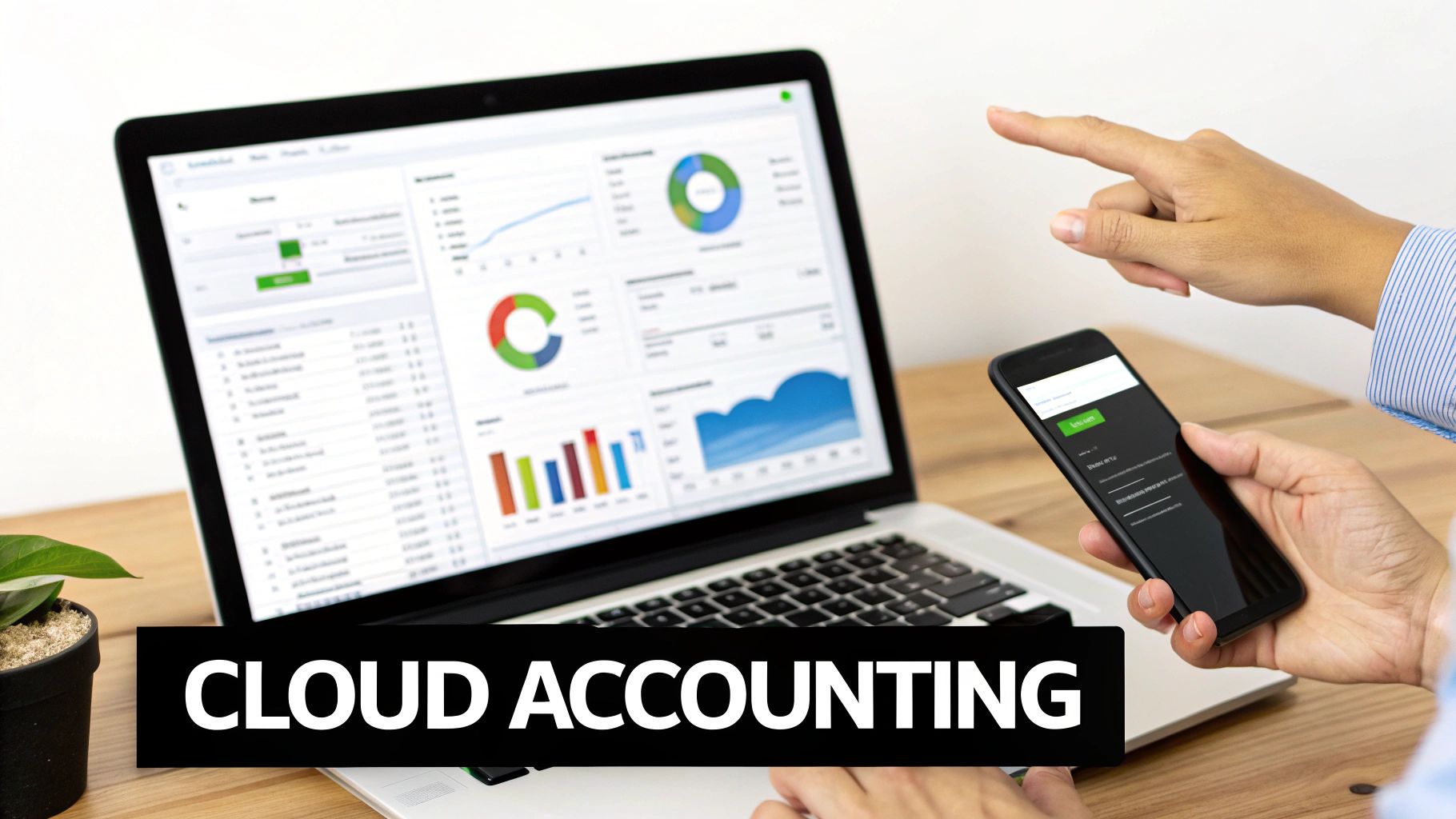 A person pointing at a laptop screen displaying cloud accounting software, with a smartphone in hand.