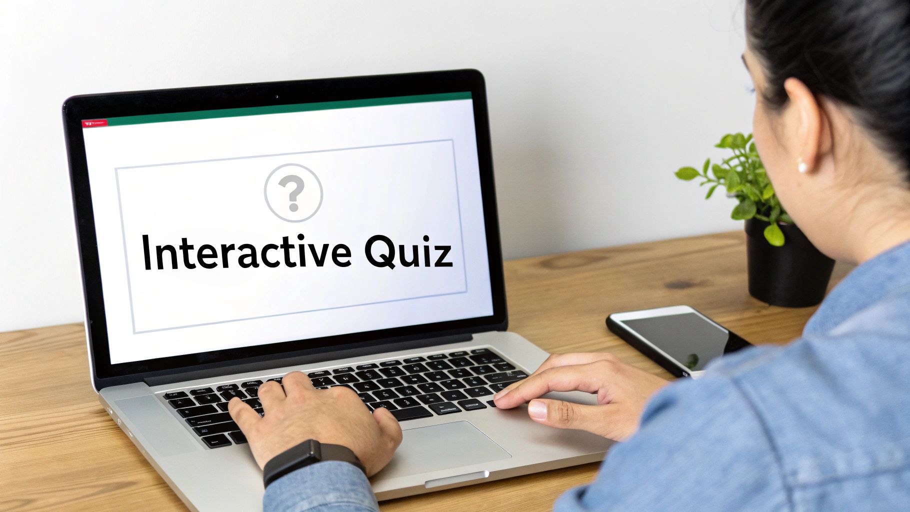 A person types on a laptop displaying "Interactive Quiz" with a question mark icon, on a wooden desk.