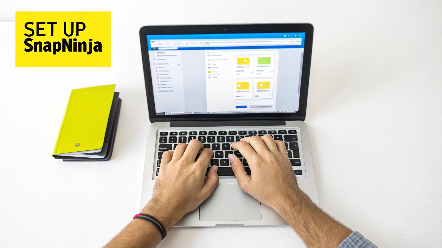 Overhead view of hands typing on a laptop with 'SET UP SnapNinja' text and notebooks.