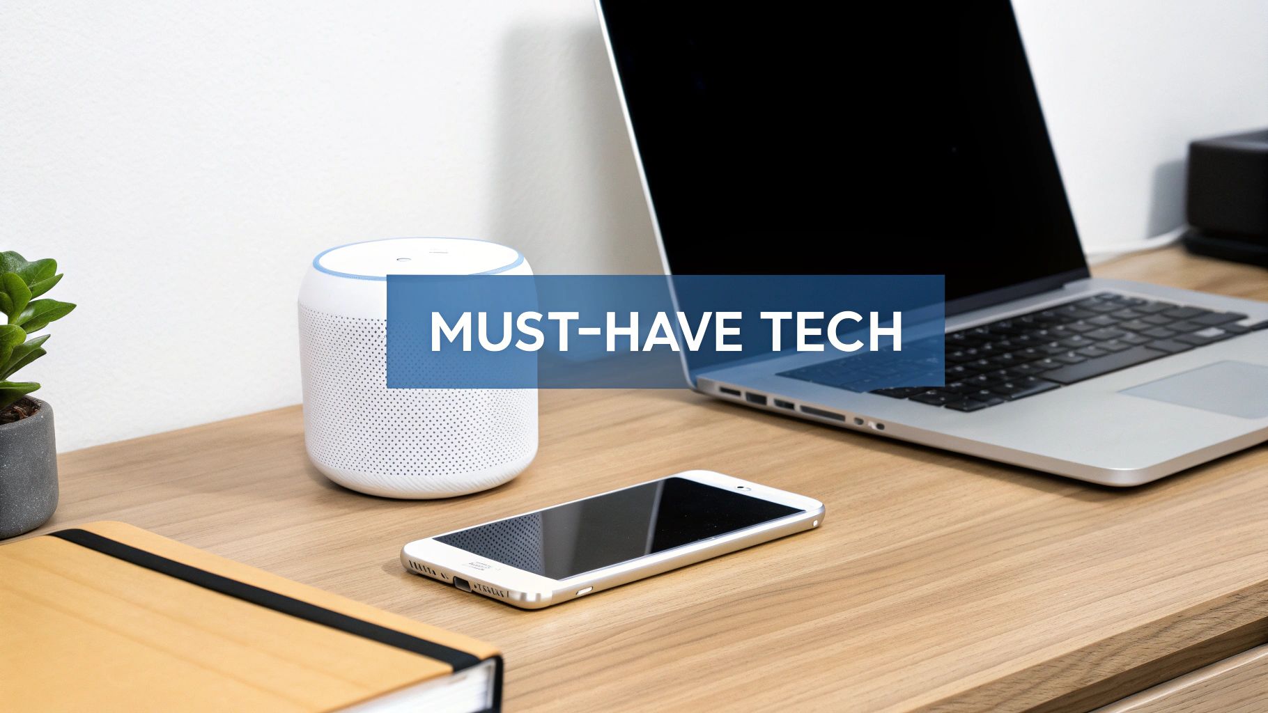 A collection of modern tech gadgets on a wooden desk, including a smart speaker, laptop, and smartphone, representing must-have electronics.