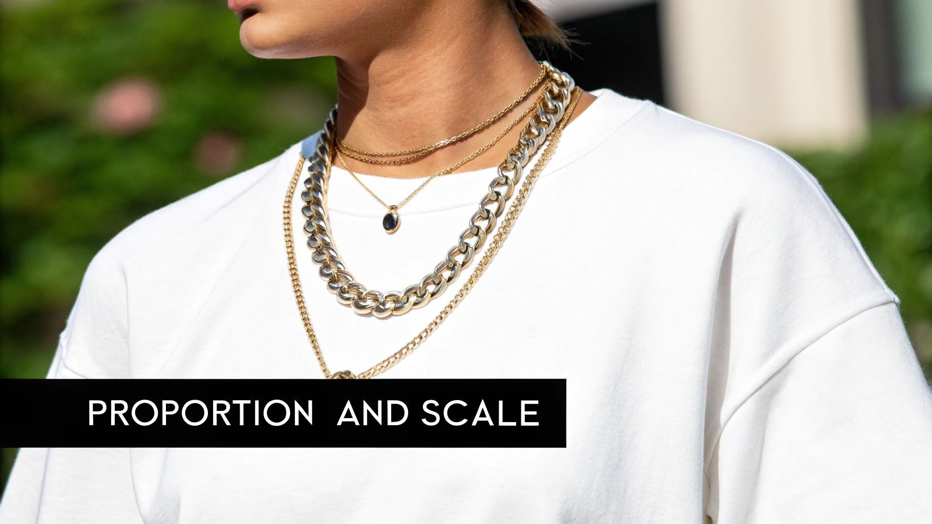 A woman wearing a statement necklace and earrings that are proportionate to her outfit.