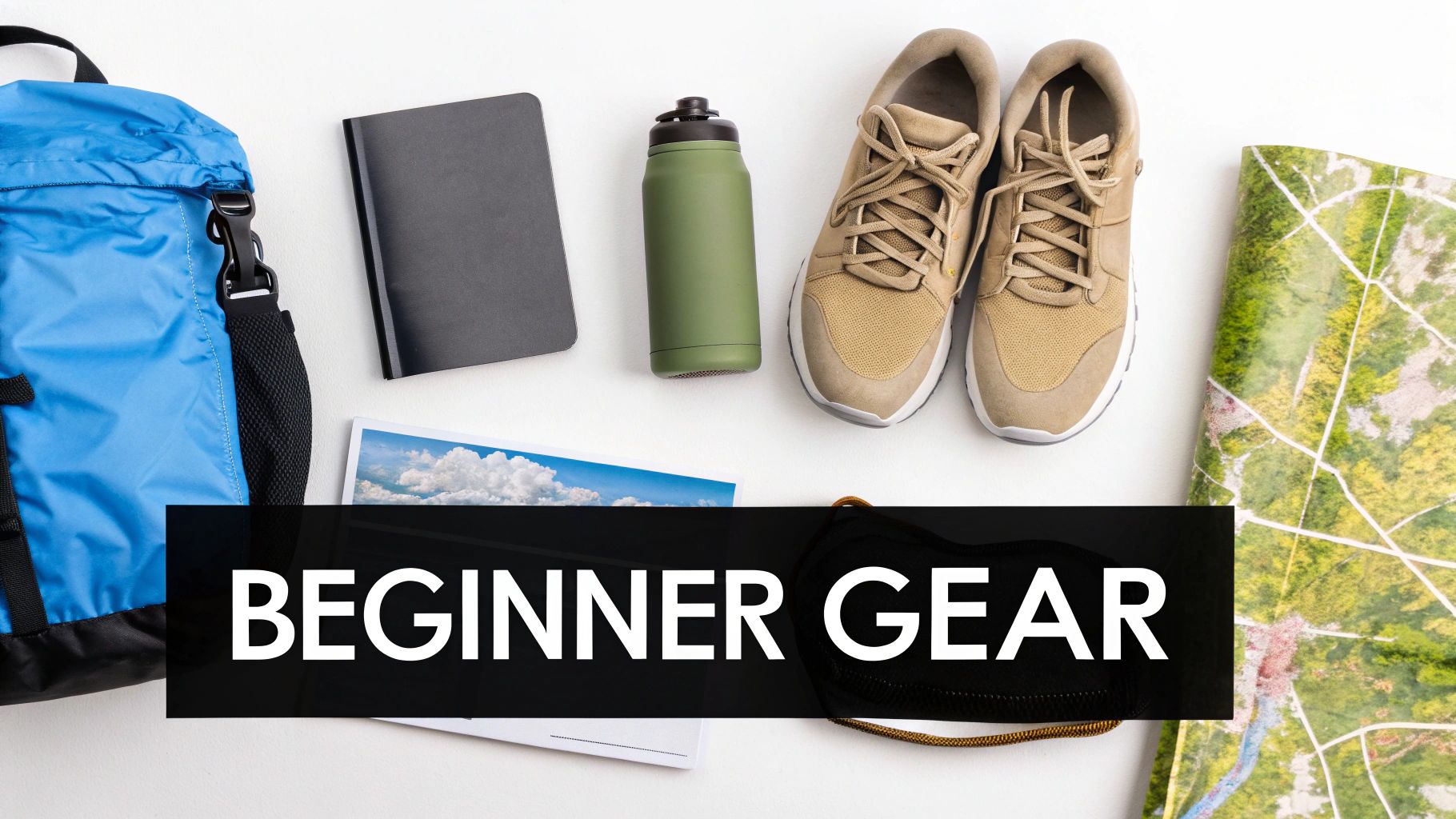 Flat lay of essential beginner hiking gear: blue backpack, black notebook, green water bottle, beige trail shoes, and a map.