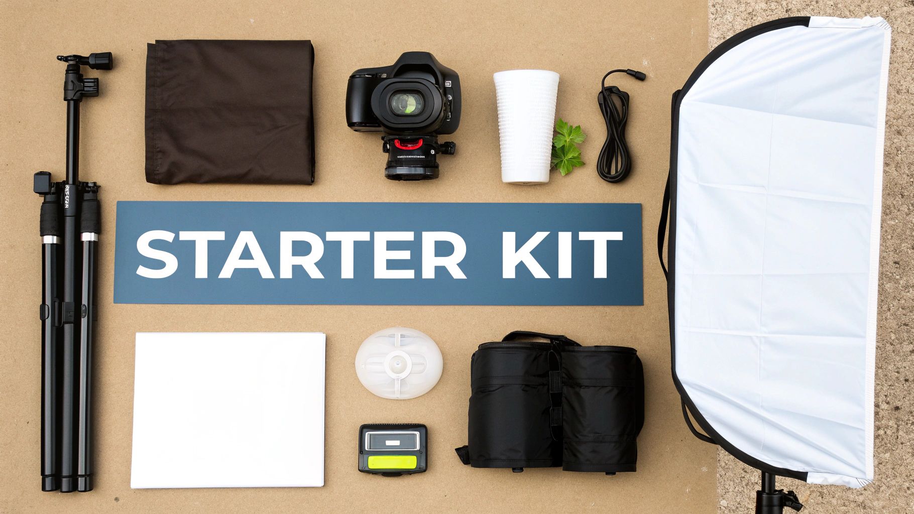 Flat lay of a photography starter kit with camera, tripod, softbox, and various accessories on a neutral background.