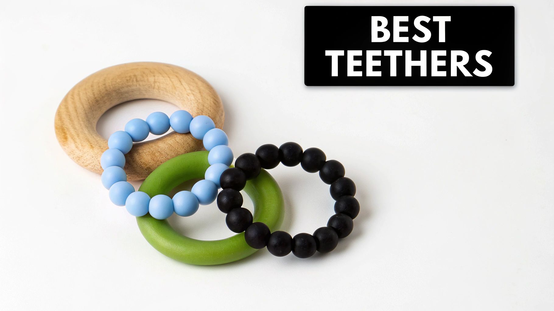Three intertwined teething rings: natural wood, light blue silicone beads, and black silicone beads, on a white background.