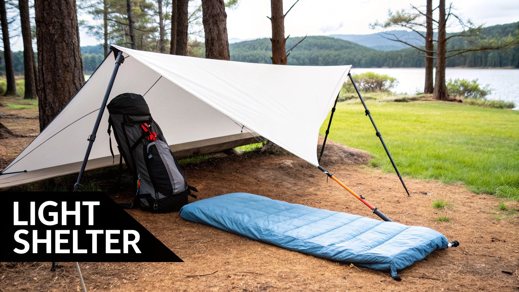 A minimalist camping setup with a white tarp, backpack, and blue sleeping pad by a lake.