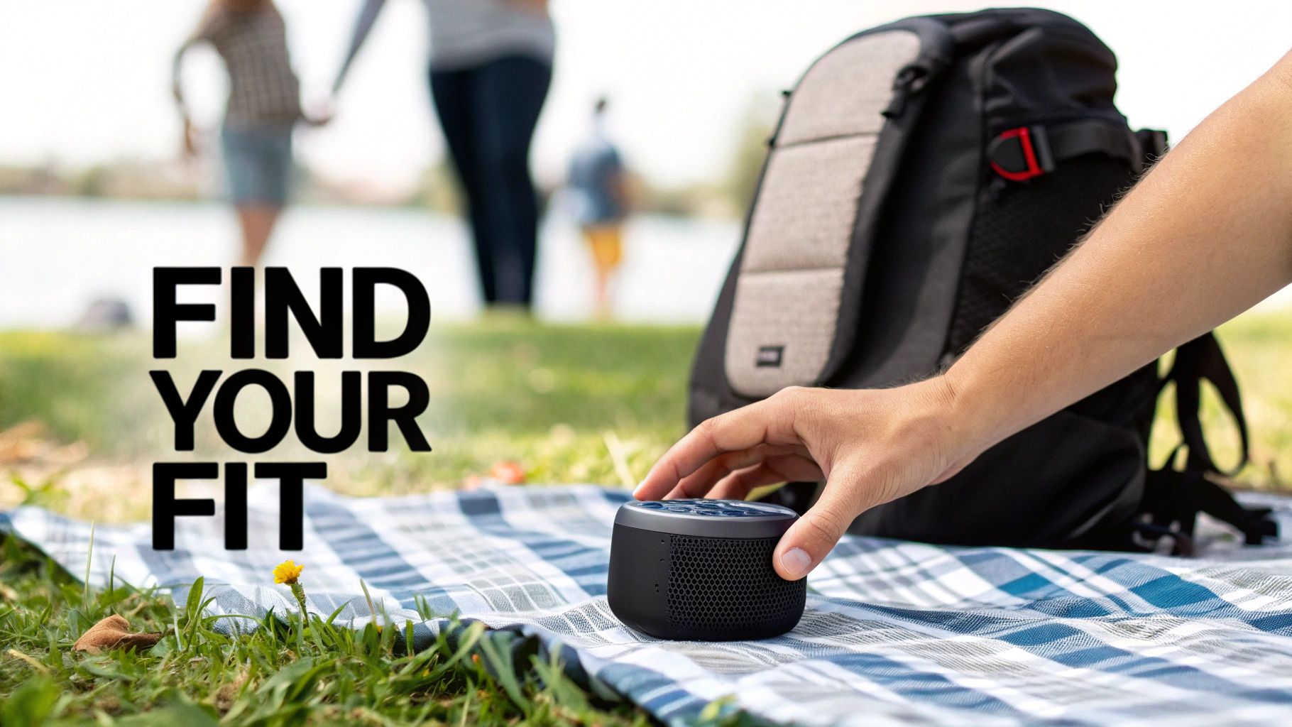 A person using a portable Bluetooth speaker during a hike, clipped to their backpack with mountains in a background.