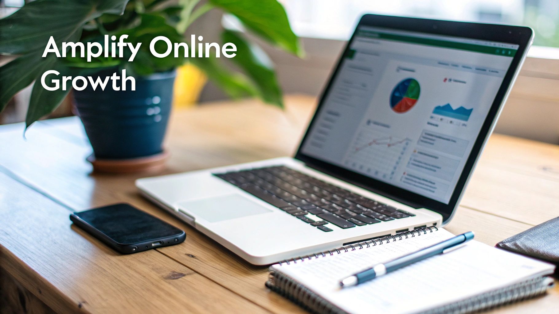 A laptop displaying business growth charts and data on a wooden desk with a phone and notebook.