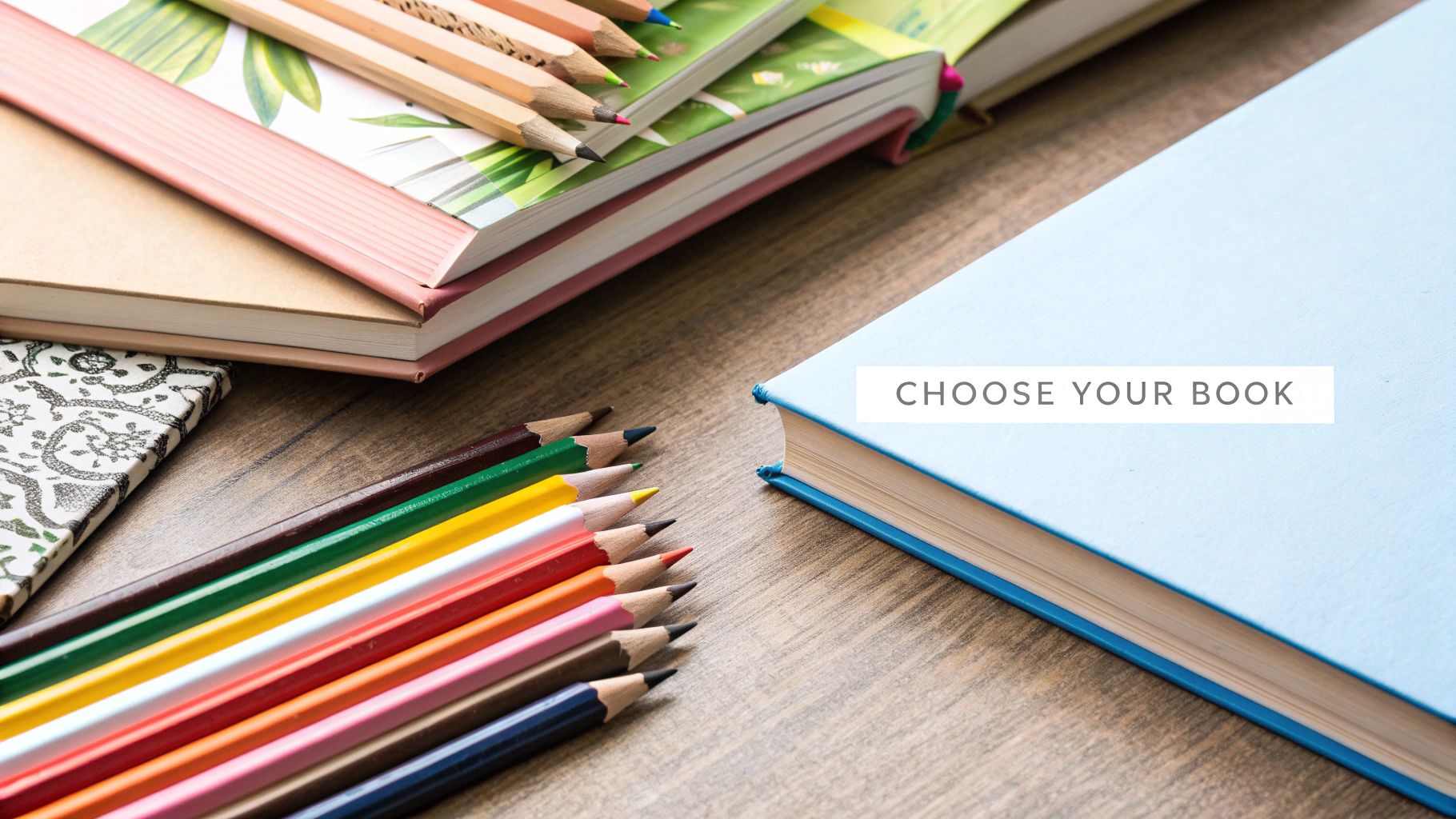 A vibrant collection of coloring books and colored pencils arranged on a wooden table.