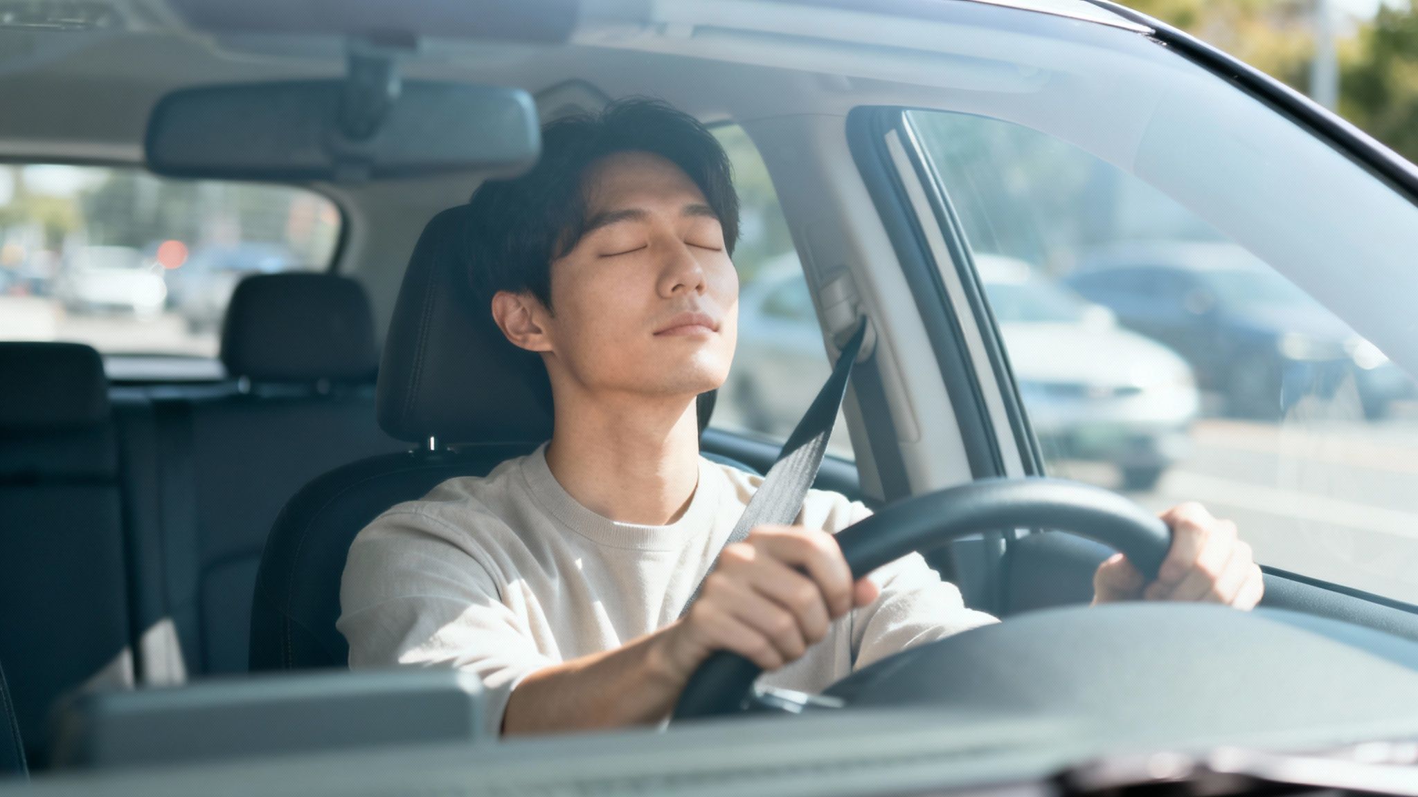 A serene man with closed eyes practices mindfulness while resting in the driver's seat.