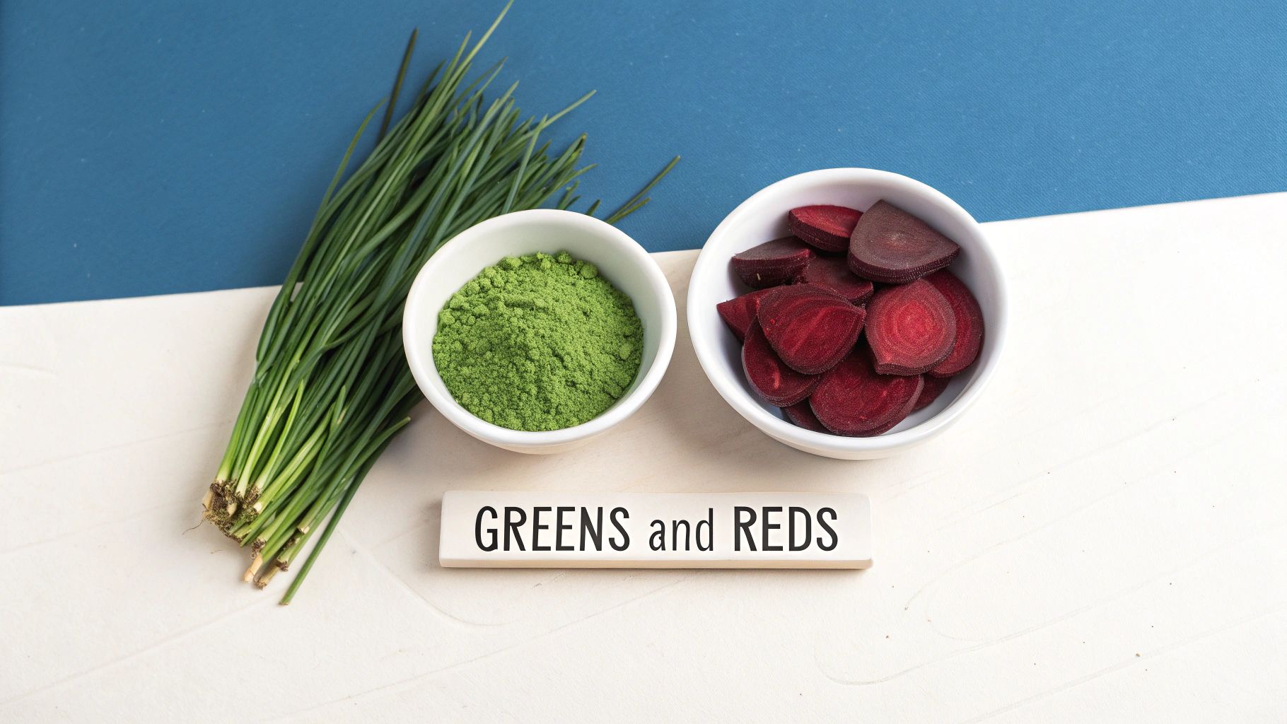 Fresh chives, green superfood powder, and sliced beets in bowls, with a 'GREENS and REDS' sign.