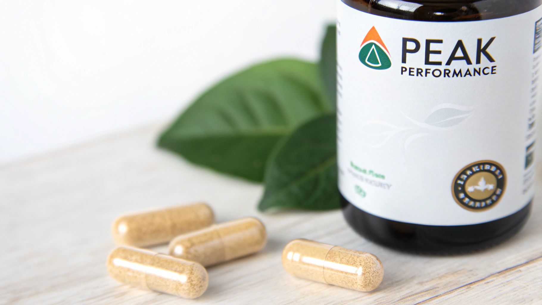 A bottle of Peak Performance supplement, light brown capsules, and green leaves on a light wooden surface.