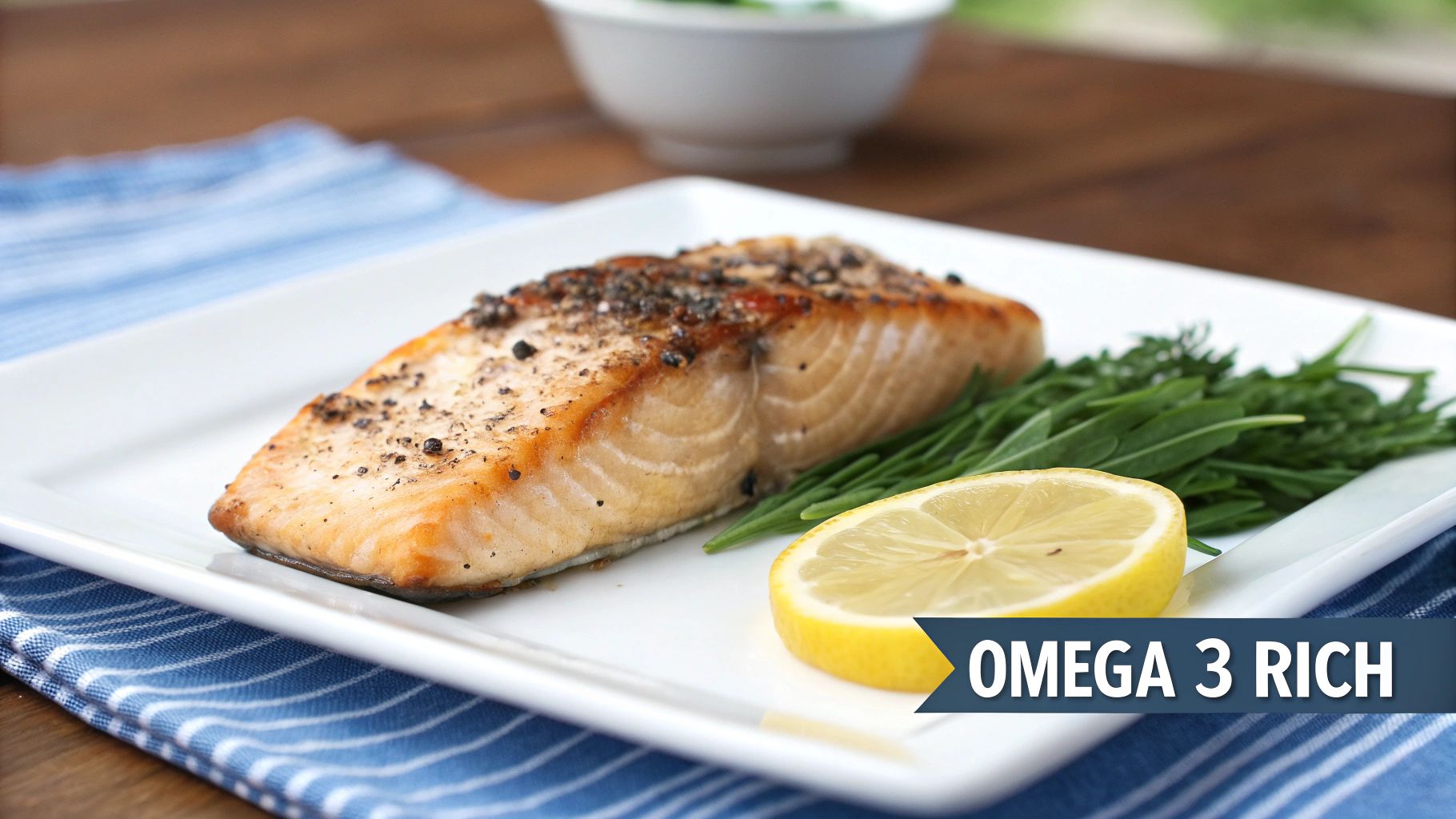 A perfectly cooked salmon fillet seasoned with pepper, lemon slice, and fresh greens on a white plate.