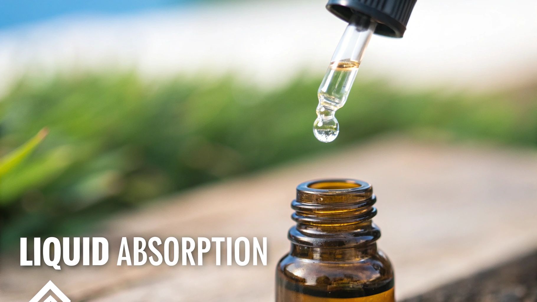 A clear liquid drop hangs from a glass dropper above an amber essential oil bottle.