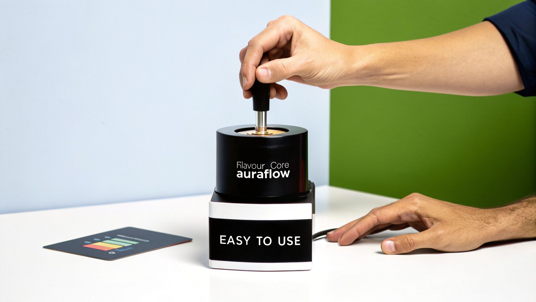 A person's hands operating a black and white 'Flavour Core auraflow' device.