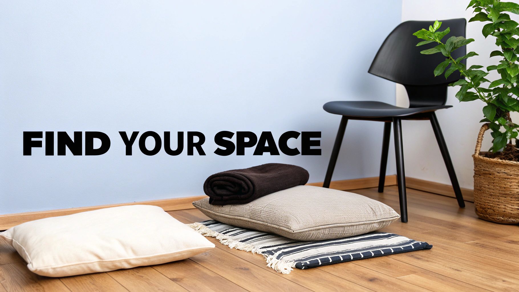 A light blue wall with 'FIND YOUR SPACE' text, a black chair, and cushions on a wooden floor.