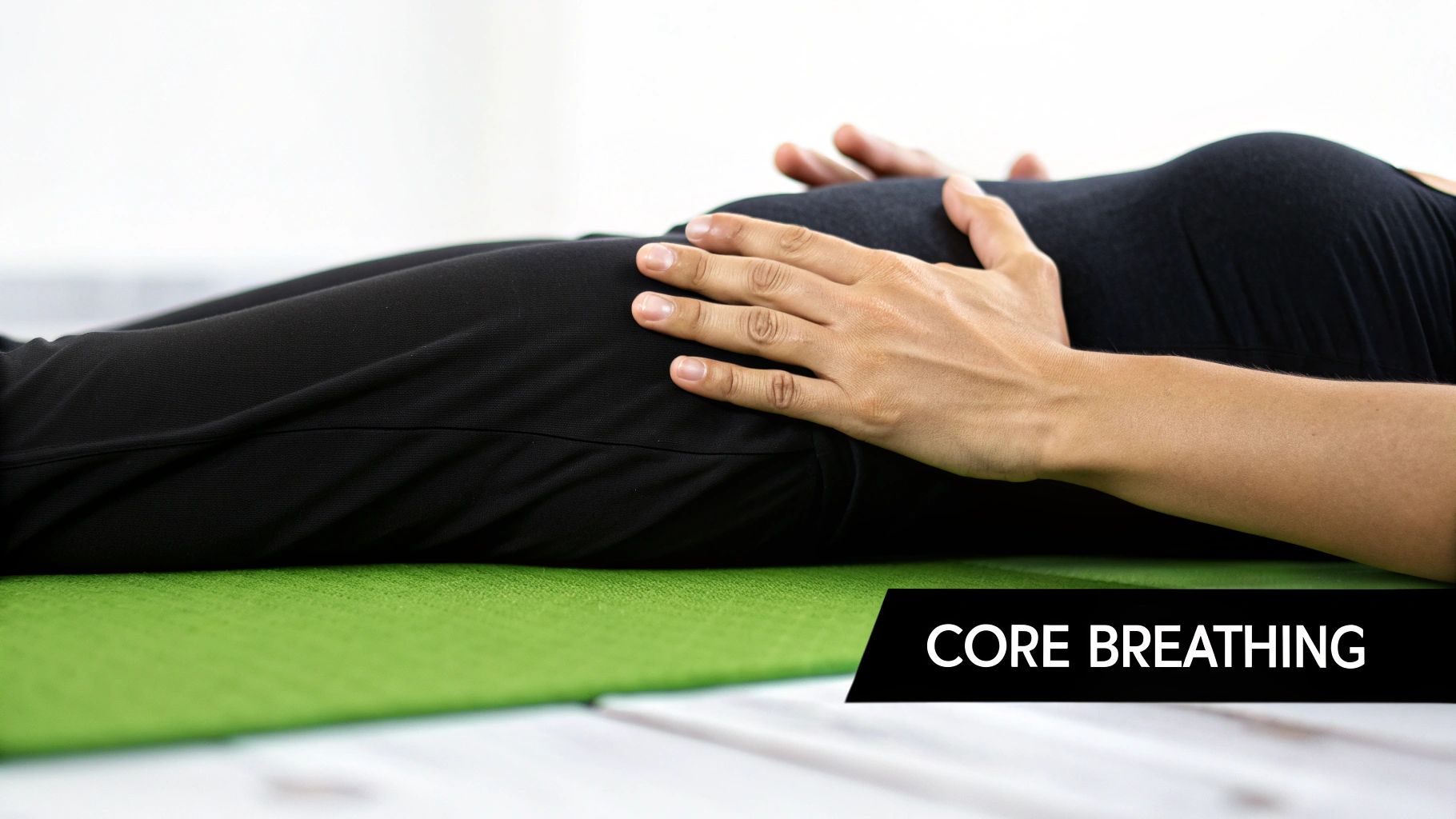 A person sitting on a yoga mat in a comfortable position, practising a breathing exercise.