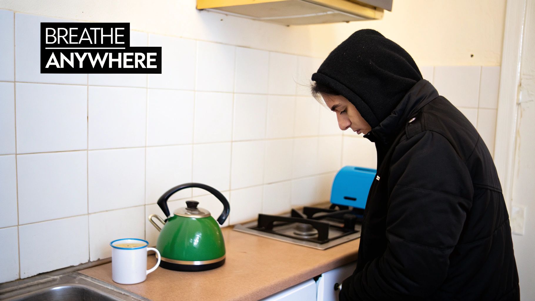 A person taking a mindful moment to breathe while waiting for their kettle to boil in a modern kitchen.