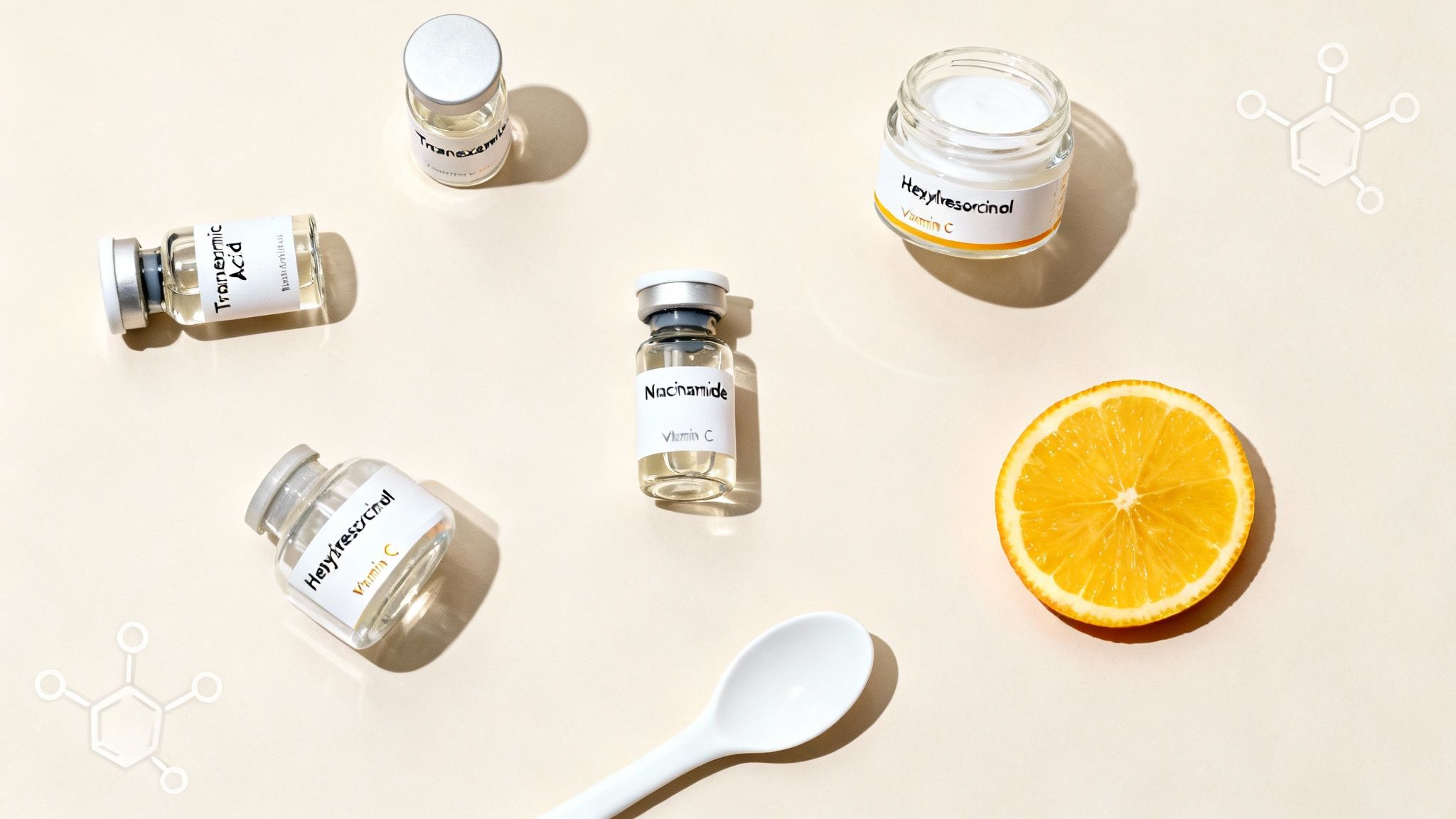 Ingredientes para el cuidado de la piel como ácido tranexámico, hexilresorcinol, niacinamida y vitamina C con una rodaja de naranja.