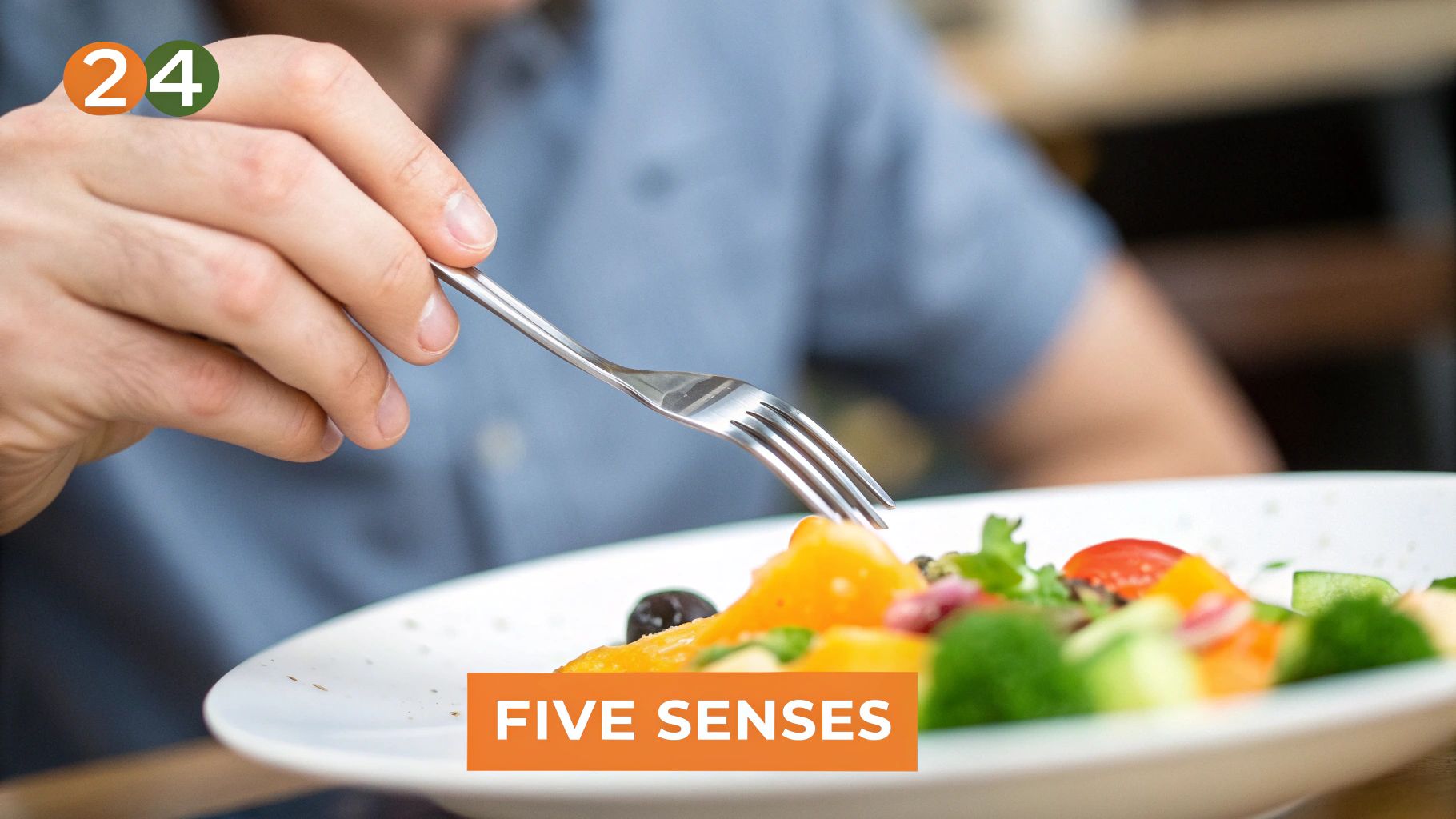 A person's hand holds a fork over a colorful salad with various fresh vegetables.