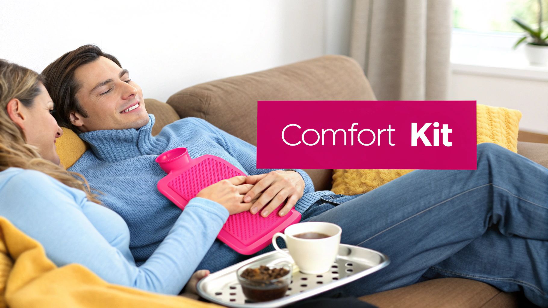 A woman comforting a man lying on a couch with a hot water bottle, text says 'Comfort Kit'.