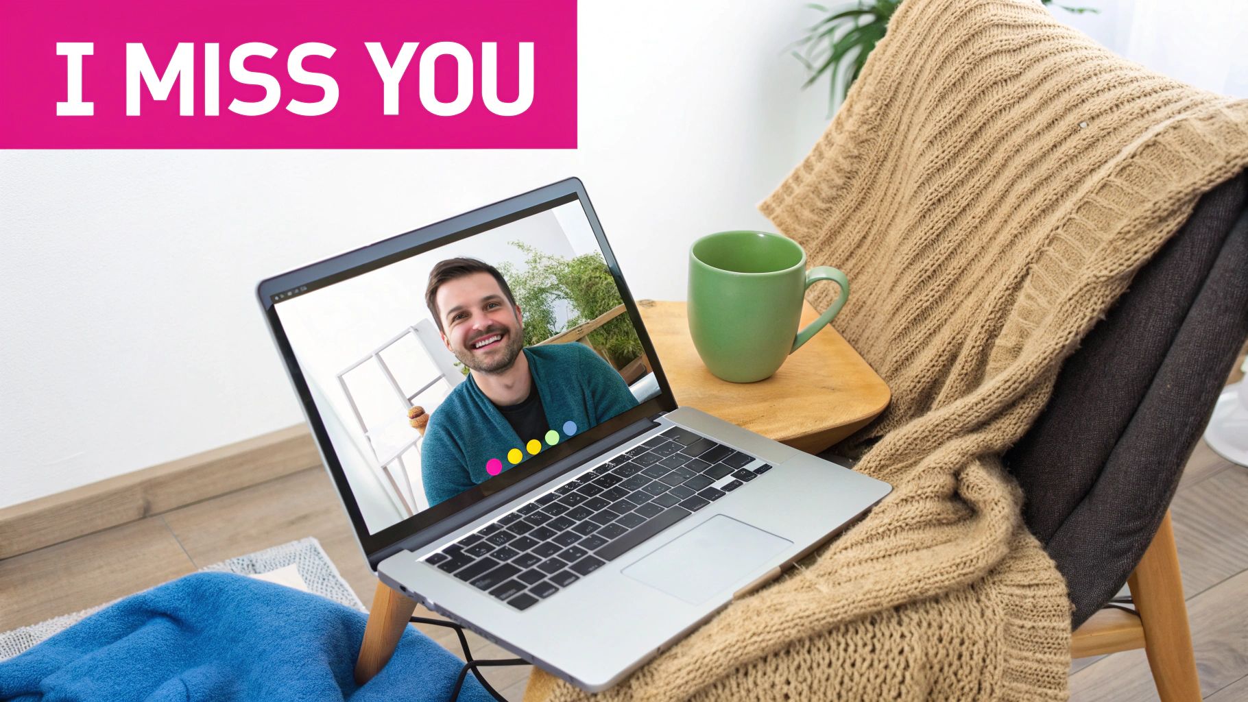 A laptop displays a video call with a smiling man, alongside an 'I MISS YOU' banner, and a cozy blanket.