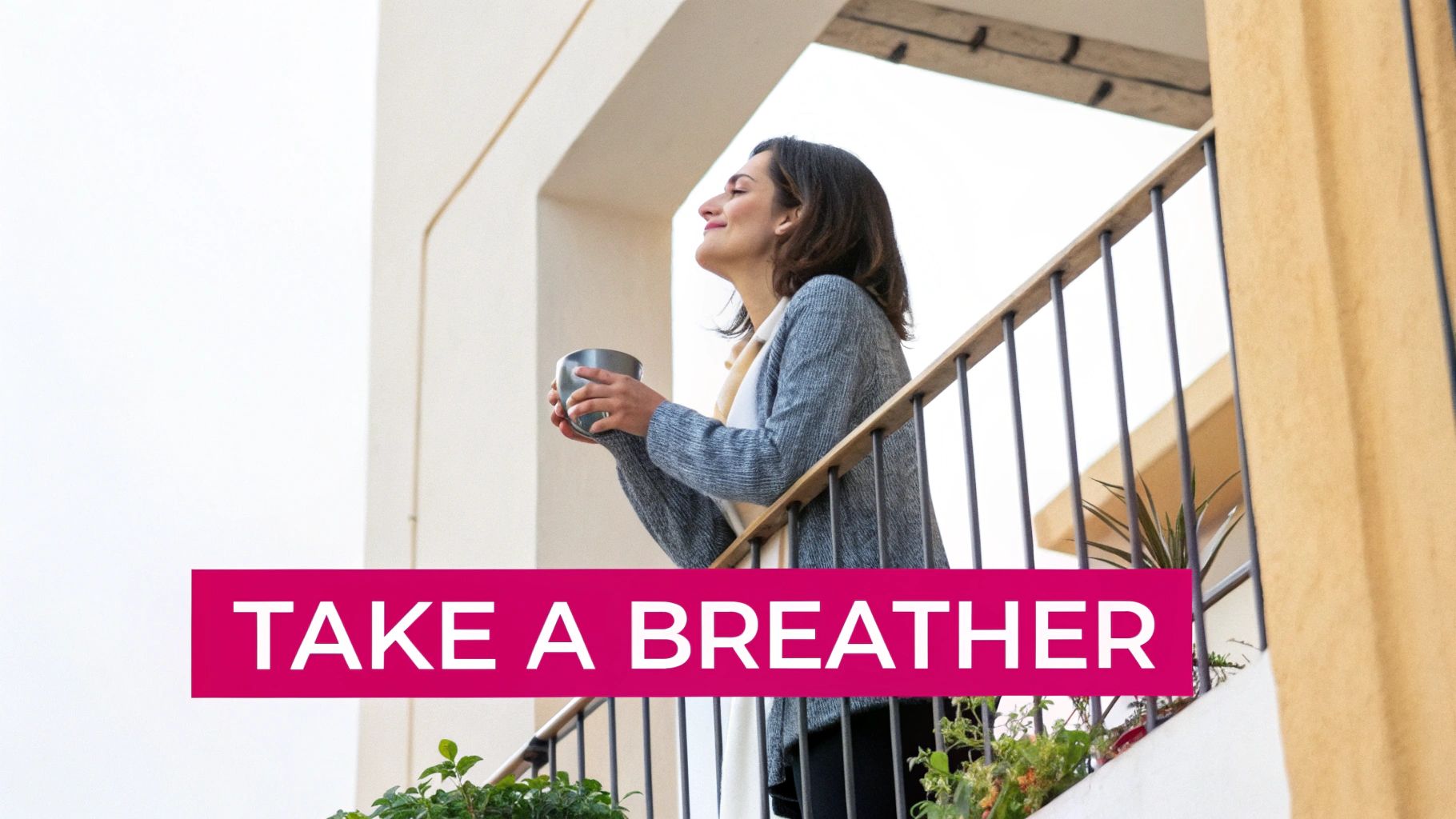 A happy woman stands on a balcony holding a cup, taking a moment to relax.