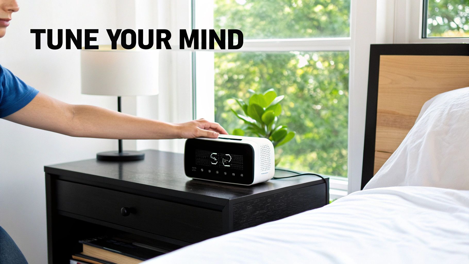 Person's hand adjusting a white digital alarm clock on a black nightstand by a bed.