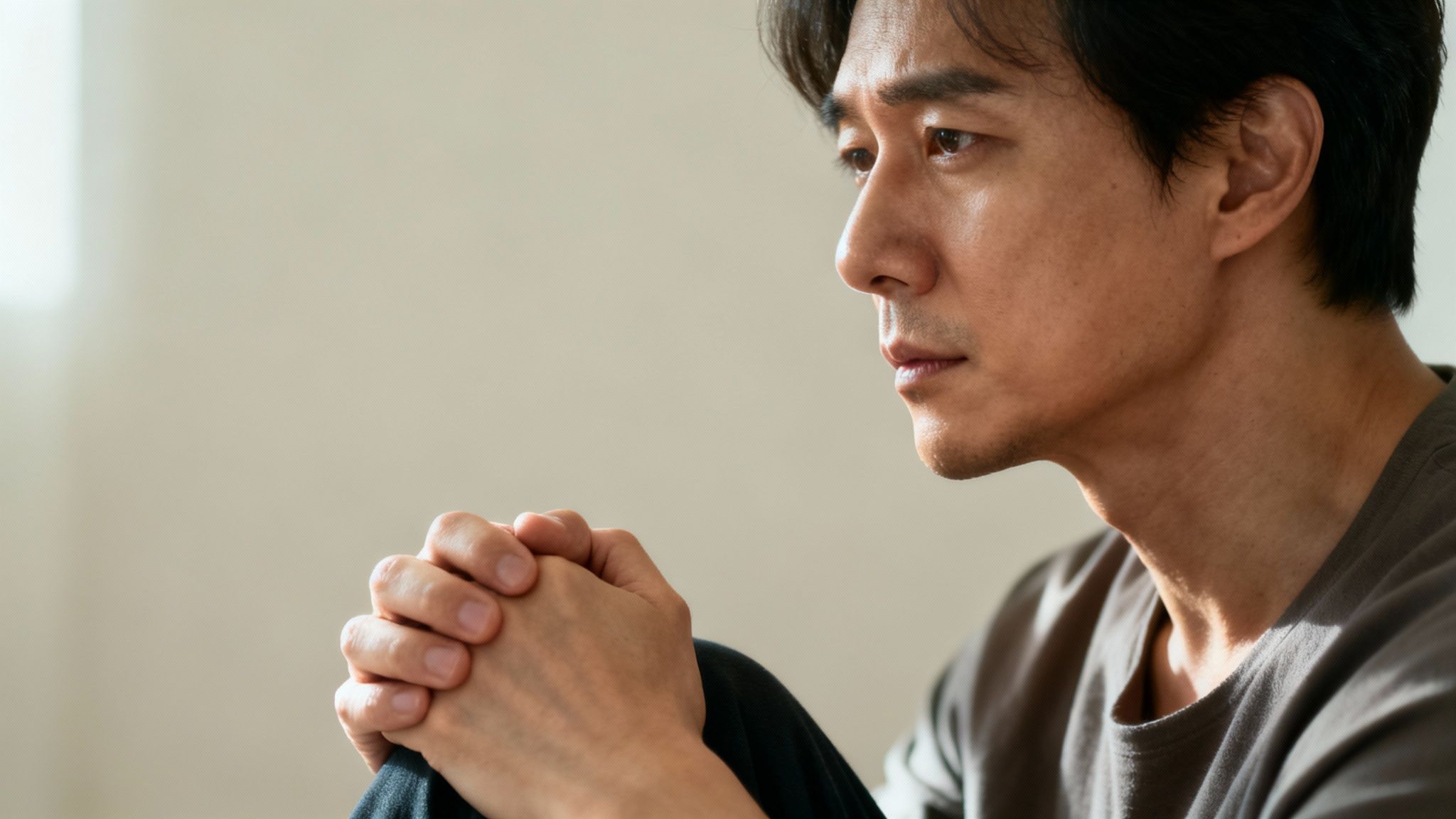 A person's face partially obscured by shadows, representing hidden or suppressed emotions.