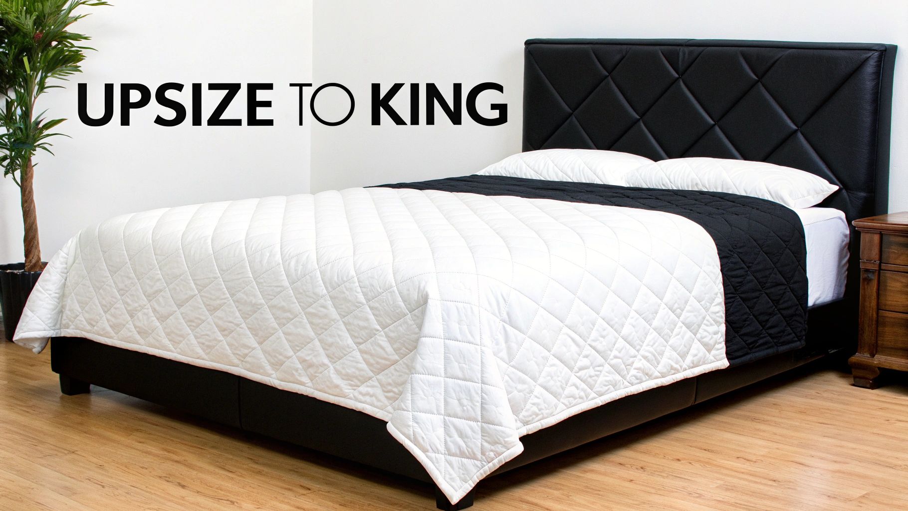 A luxurious bed with a king-sized quilt draped over a queen mattress, showing ample overhang.