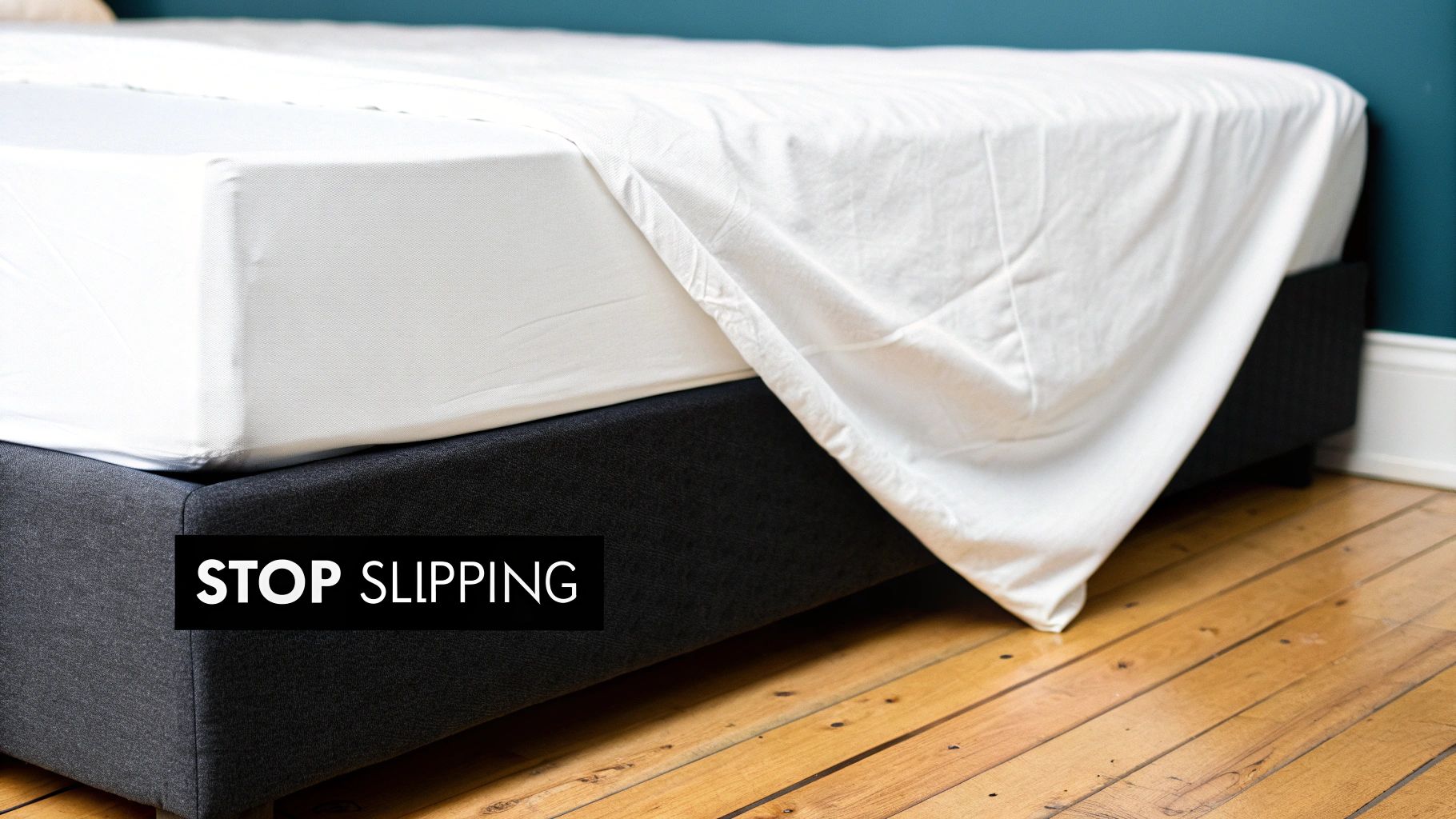 A person struggling to fit a white fitted sheet onto the corner of a mattress.