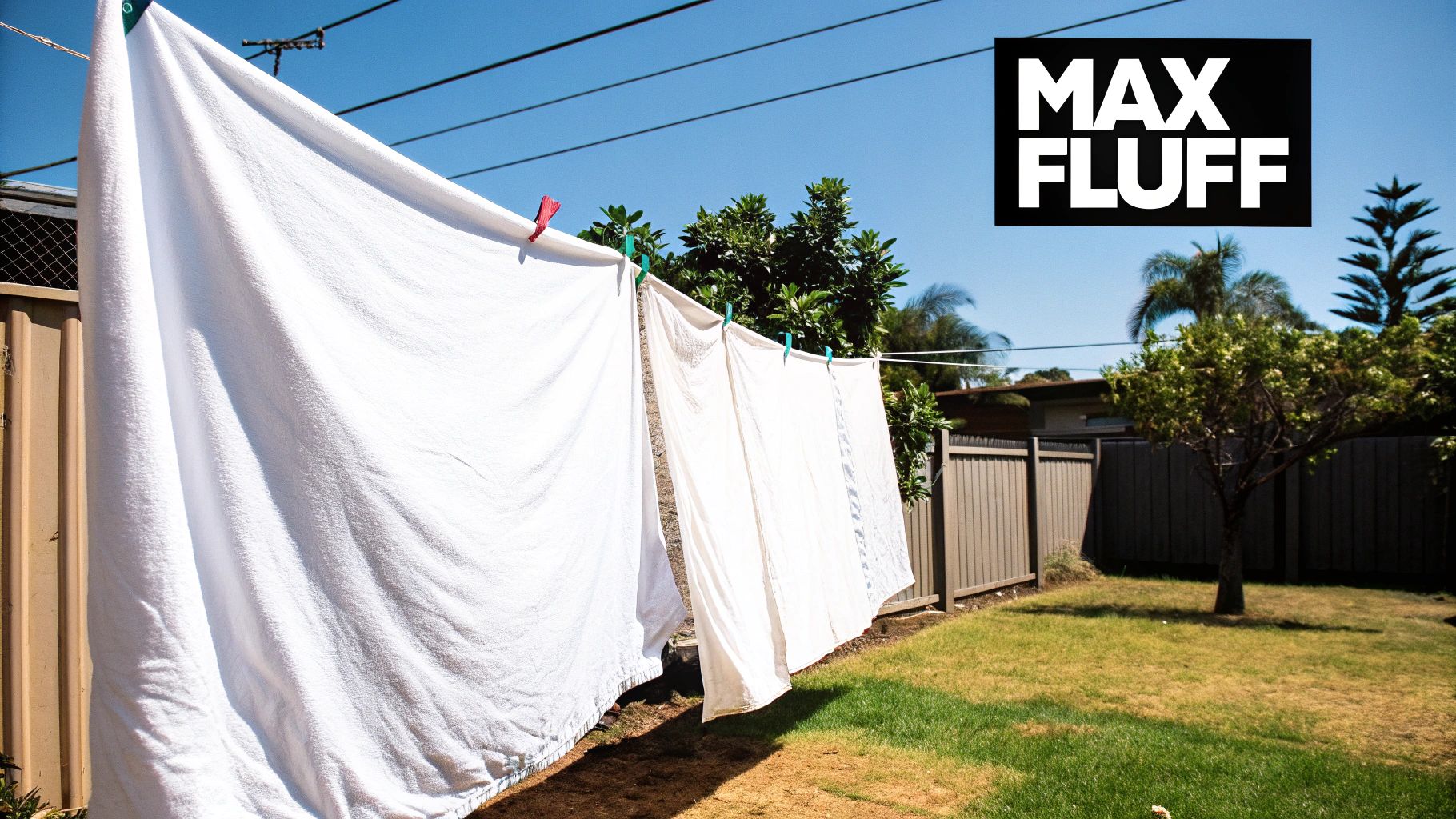 A fluffy, white doona draped over a clothesline in a sunny, breezy garden