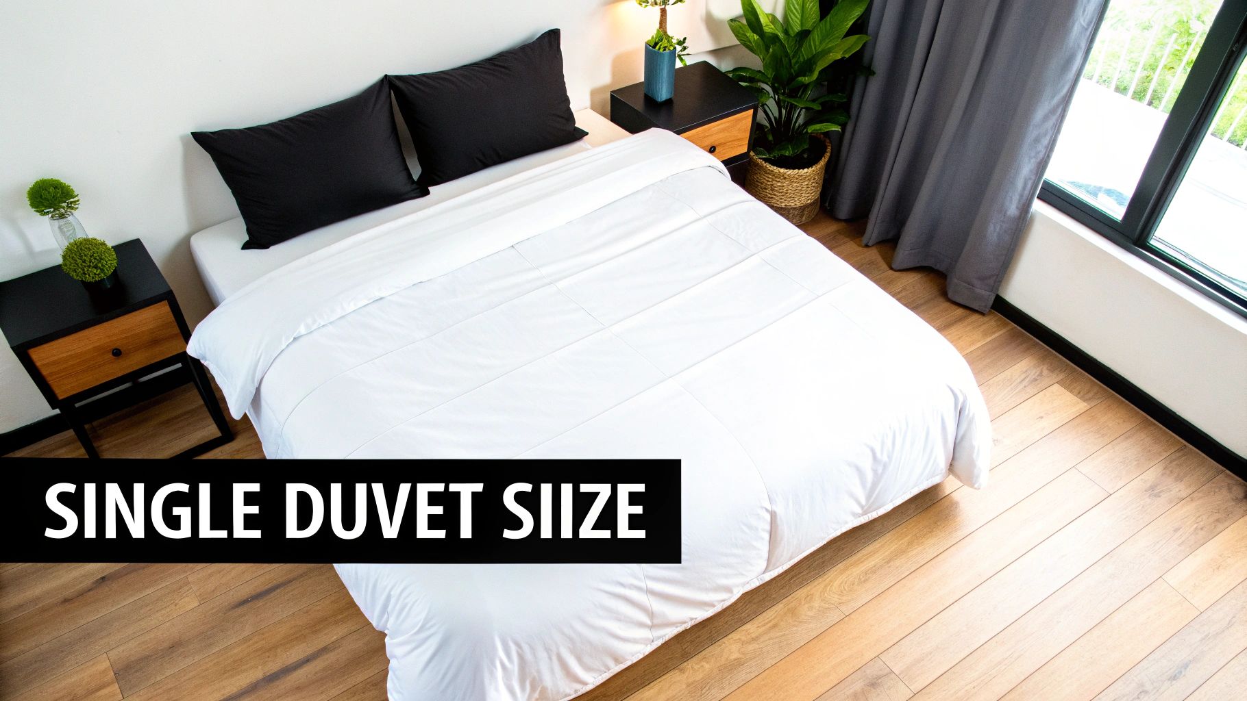 A modern bedroom features a white single duvet on a bed with black pillows and nightstands.