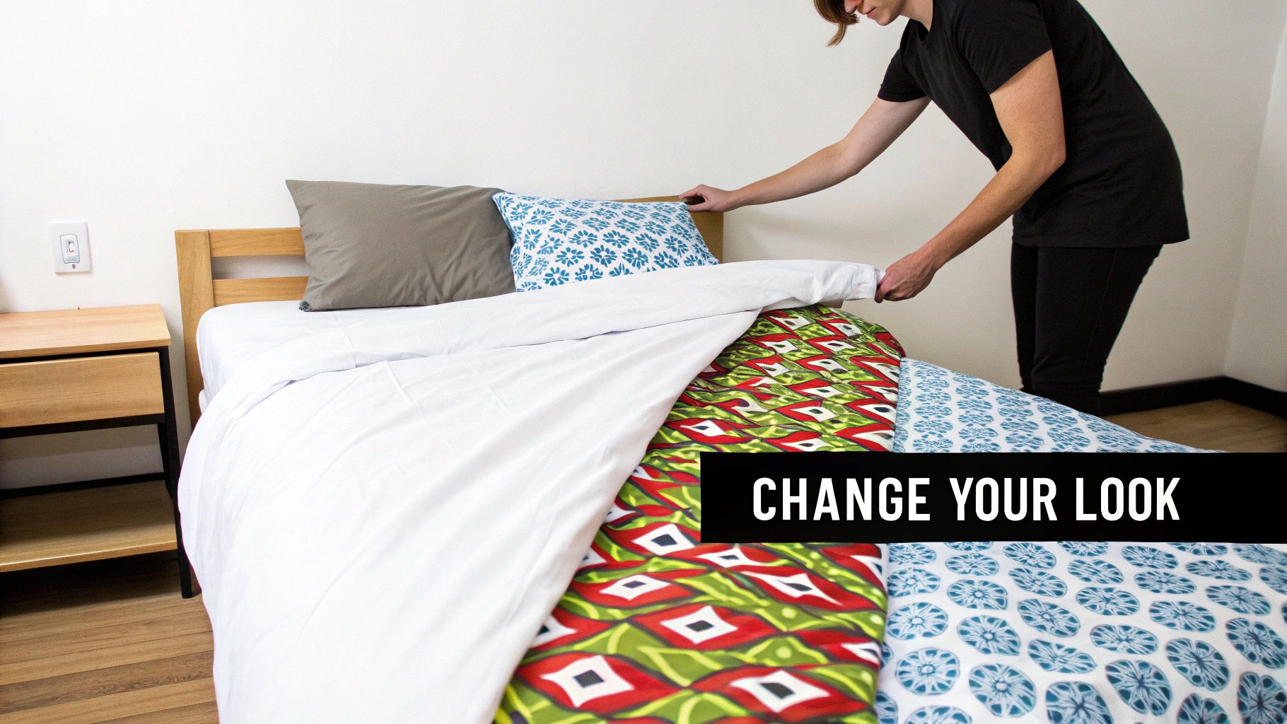 A person making a bed, revealing multiple colorful duvet patterns underneath a white cover.