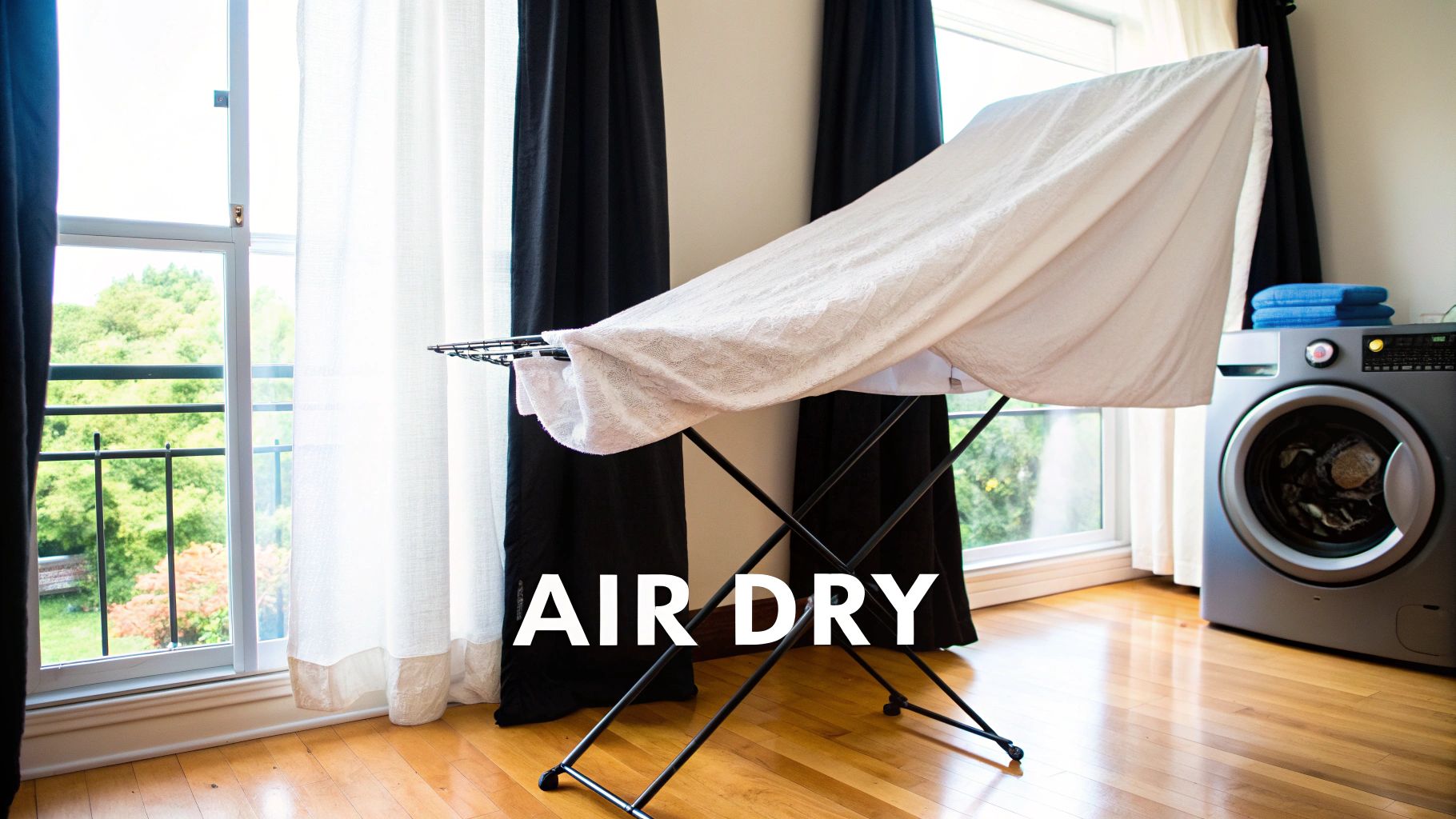 A white towel draped over a drying rack, air-drying by a window next to a washing machine.