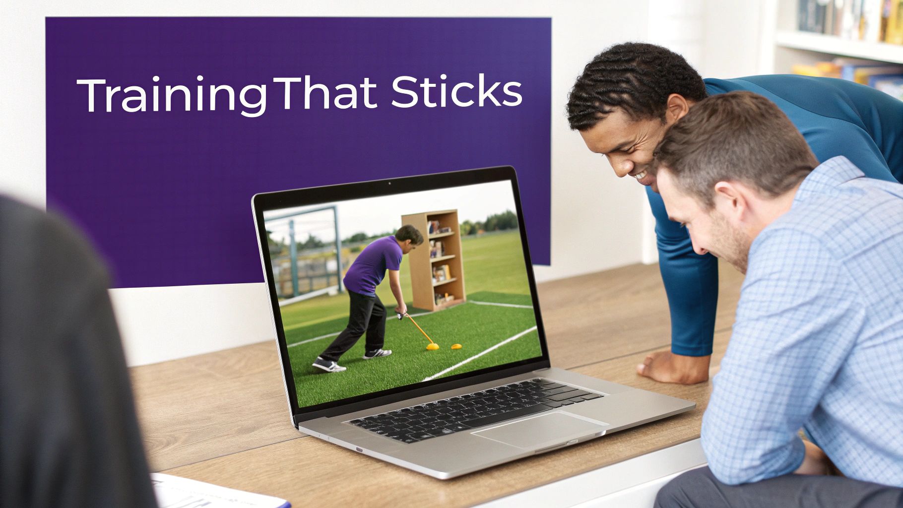Two professionals reviewing online golf training video on laptop computer in modern office