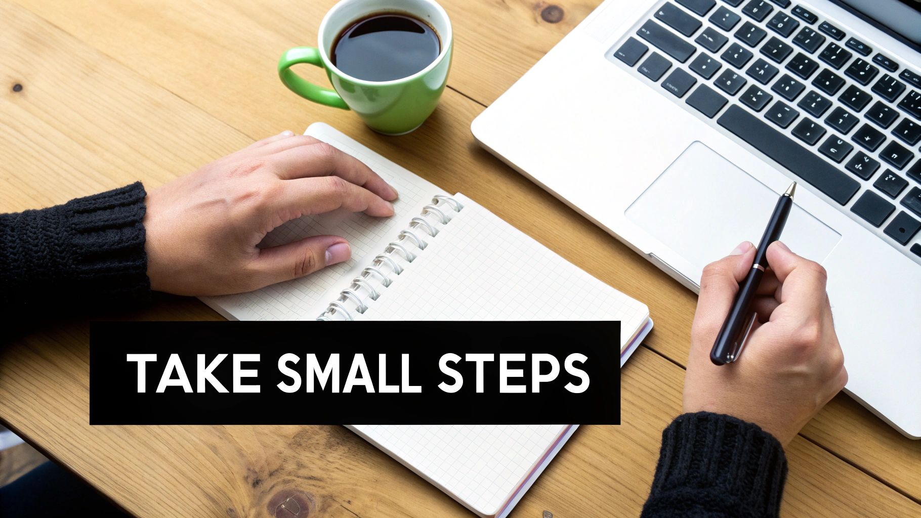 A person journaling at a desk with a laptop and a cup of coffee, symbolizing reflection and planning.