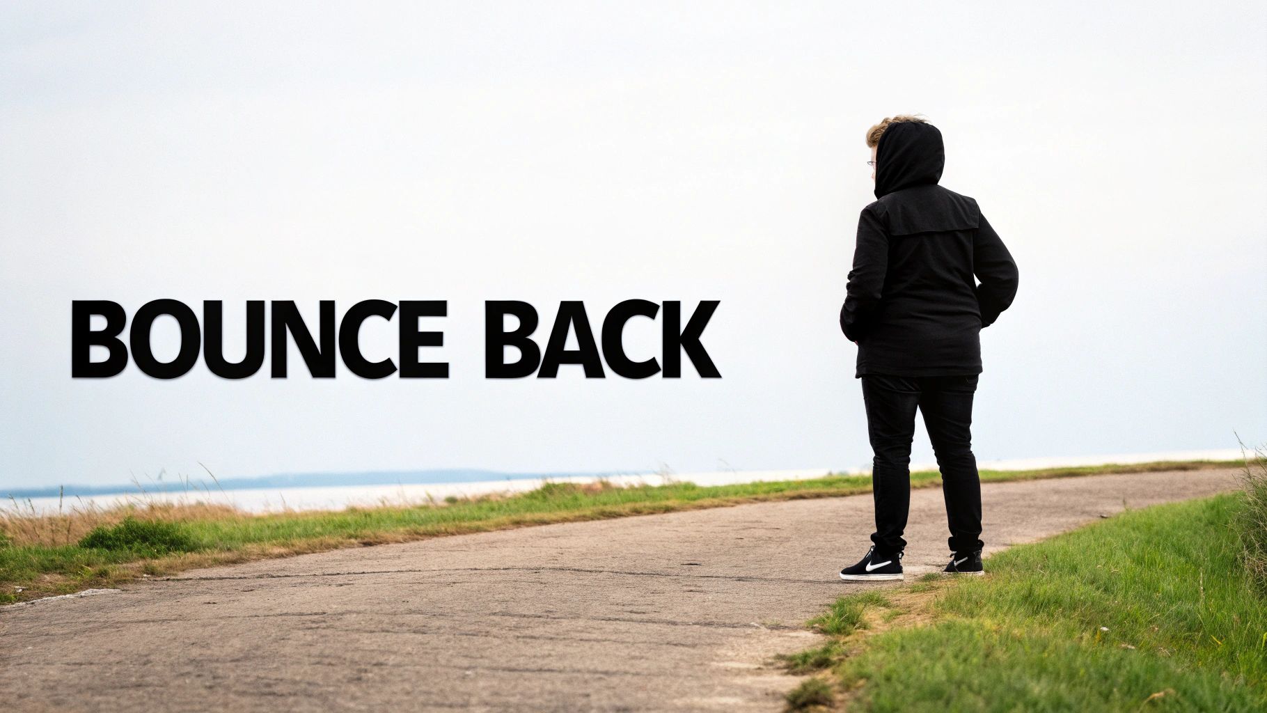 A lone tree stands strong on a cliff, weathering a storm, symbolizing resilience.