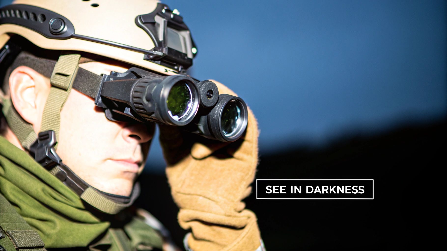 A person in tactical gear and helmet uses night vision binoculars to see in the darkness.