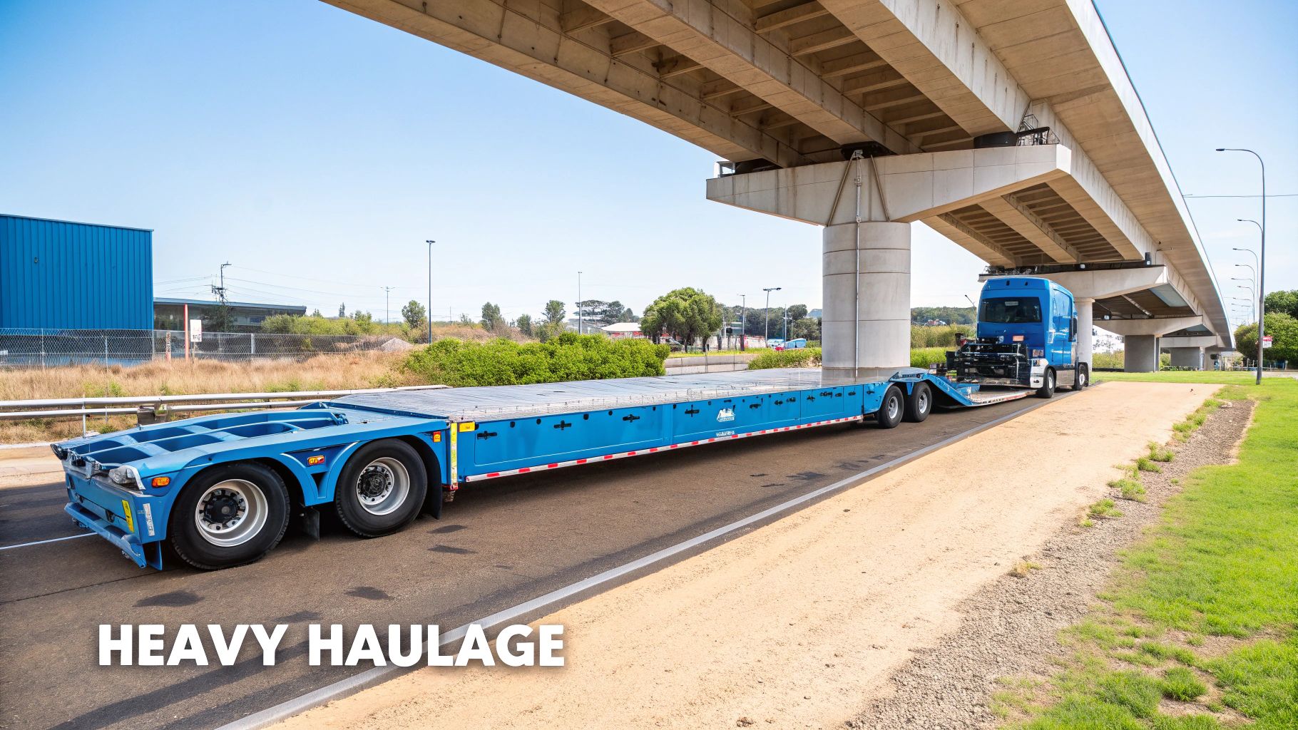 A low loader transport truck carrying a heavy piece of construction machinery on a highway