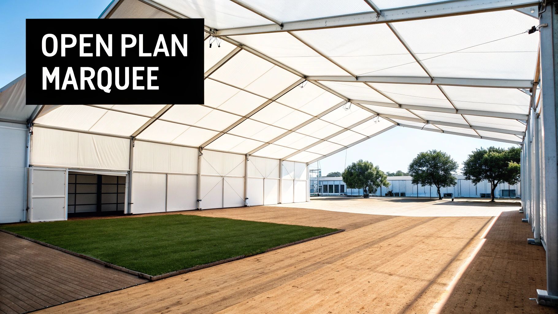 Spacious open-plan white event marquee interior featuring a green turf section and a wooden walkway.
