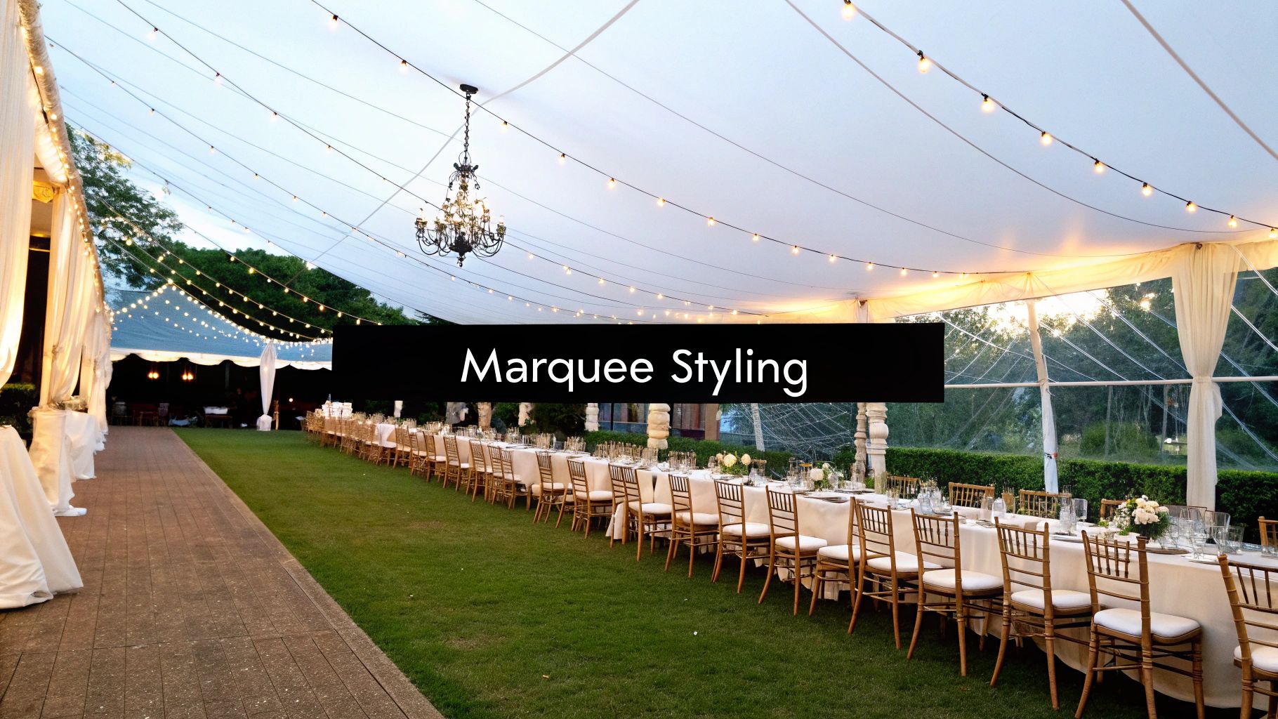 Elegant outdoor garden party marquee with long dining tables, chairs, string lights, and a chandelier.