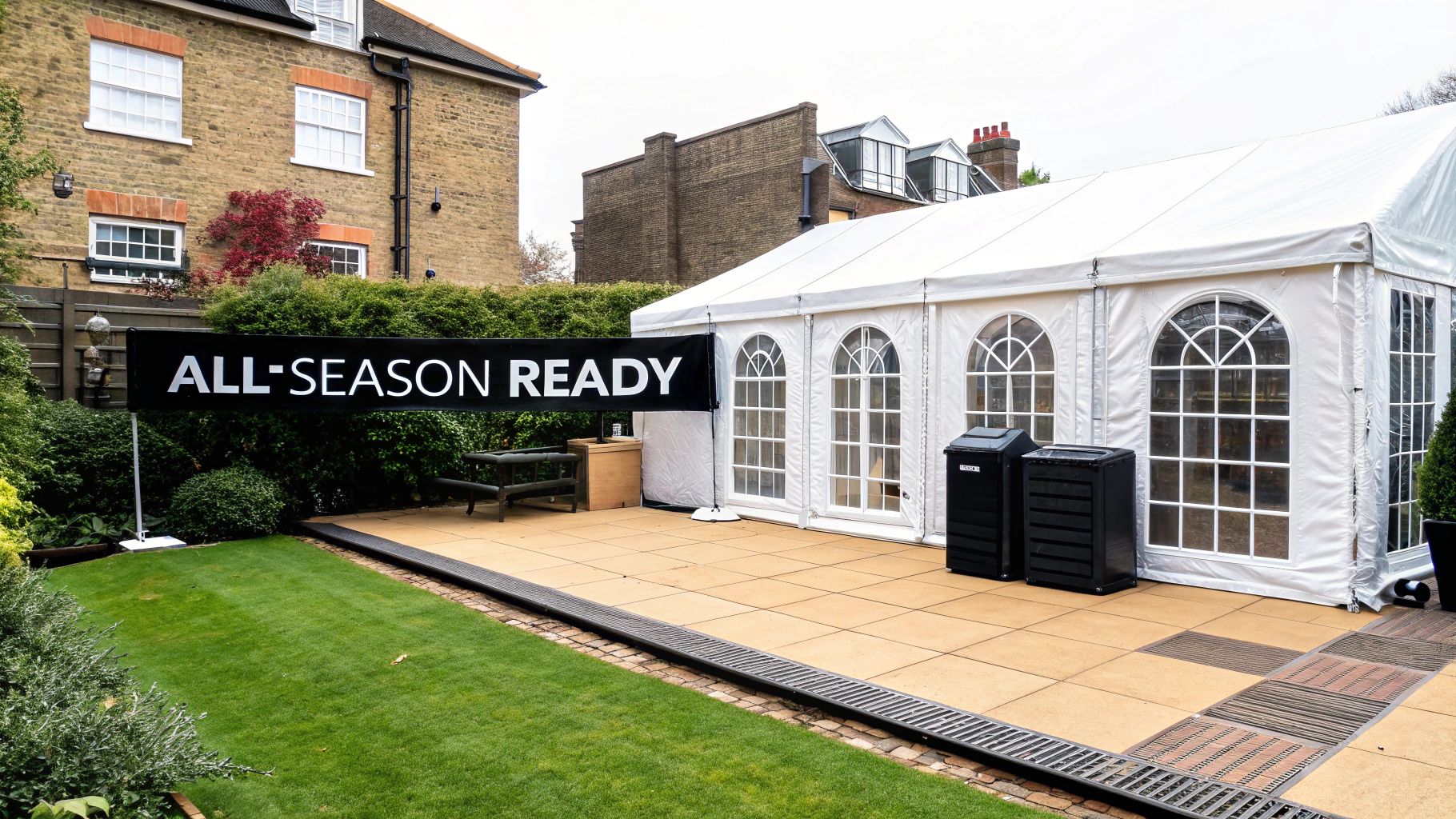 A large white party tent set up on a patio next to a green lawn with an "ALL-SEASON READY" banner.
