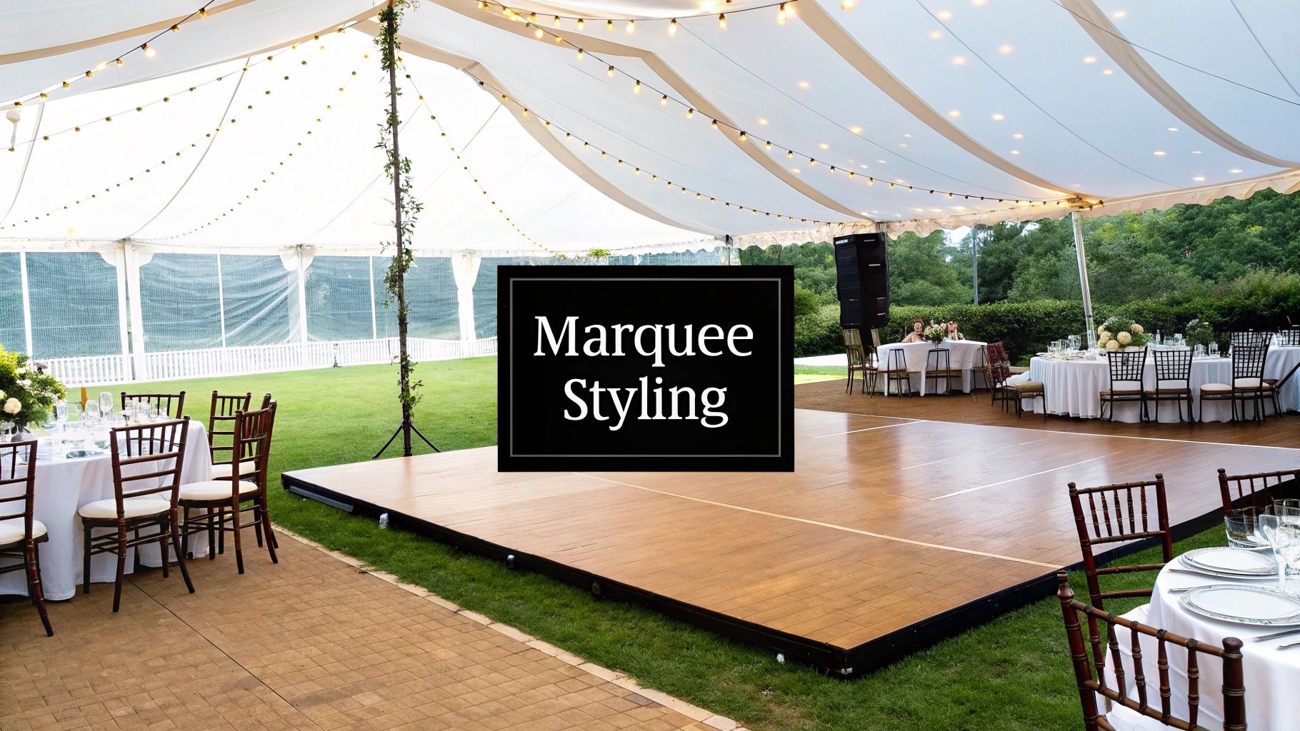 Elegant outdoor wedding reception under a white marquee tent with dance floor and decorative lighting.