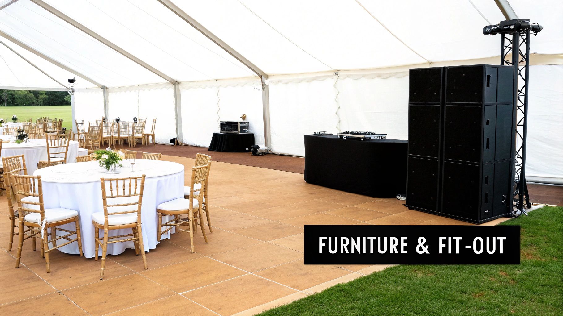 A spacious white marquee tent with elegantly set round tables, chairs, and a professional DJ setup.