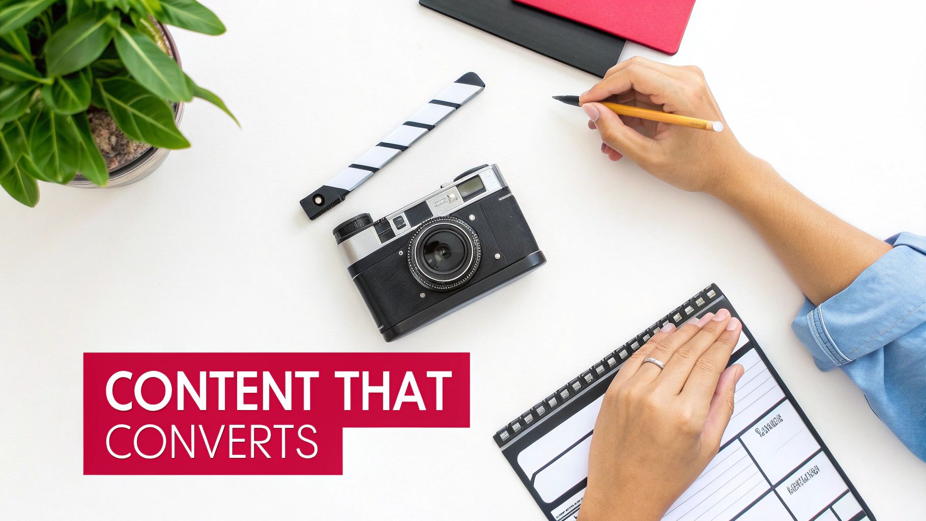 Overhead shot of a person working at a white desk with a camera, plant, and notebooks, with 'CONTENT THAT CONVERTS' text overlay.