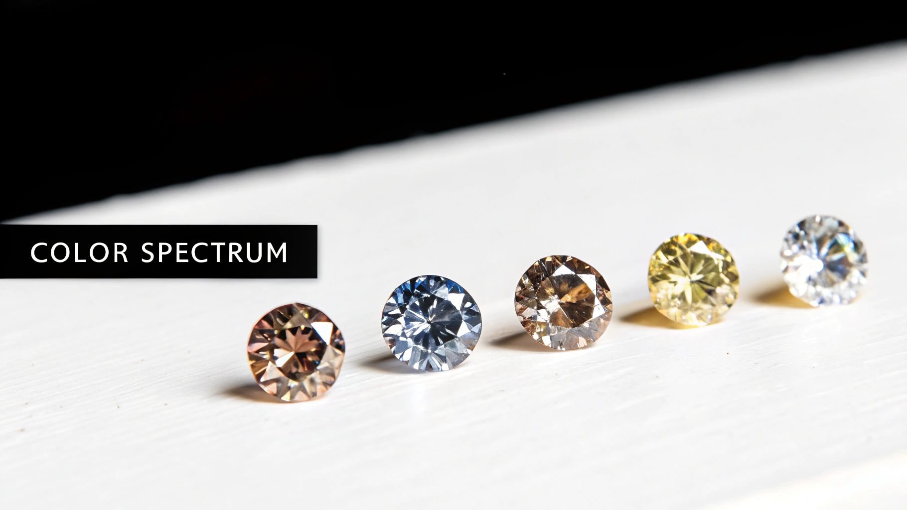 Five diamonds displaying color spectrum from brown to colorless representing diamond color grading scale